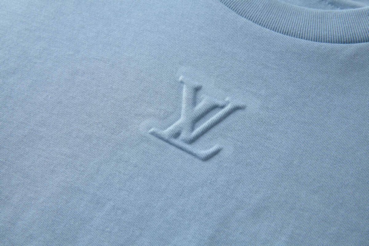 P110 LOUIS VUITTON 压花标识短袖 面料：采用32支双纱精梳棉。 面料：螺纹采用1*1配套索罗娜。 工艺：原版定制1：1LV标识压花模具，同比例尺寸与厚薄度。 本款T恤取材柔软棉布针织，以品牌元素点亮经典设计。肩头缝线和背后的桑蚕丝嵌花标签呈现内外翻转效果，硅质LV标识刺绣再添品牌格 调。 辅料：定制1：1洗水商标 辅料：定制1：1压花标识 尺码：S-M-L-XL 颜色：黑-白-蓝-紫-宝蓝-灰 款号：86224-818