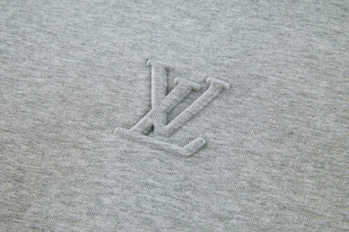 P110 LOUIS VUITTON 压花标识短袖 面料：采用32支双纱精梳棉。 面料：螺纹采用1*1配套索罗娜。 工艺：原版定制1：1LV标识压花模具，同比例尺寸与厚薄度。 本款T恤取材柔软棉布针织，以品牌元素点亮经典设计。肩头缝线和背后的桑蚕丝嵌花标签呈现内外翻转效果，硅质LV标识刺绣再添品牌格 调。 辅料：定制1：1洗水商标 辅料：定制1：1压花标识 尺码：S-M-L-XL 颜色：黑-白-蓝-紫-宝蓝-灰 款号：86224-818
