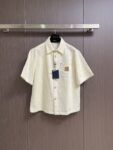 weigou_170816_0_6129b9fe42 P215 LV 桑蚕丝混纺短袖衬衫,本品采用桑蚕丝混纺梭织面料,经预缩与抗皱处理,布面带有细腻竖条肌理,触感清凉顺滑,兼具蚕丝的亲肤透气与棉的挺括耐用,适配夏季穿着。经典翻领采用平车包边工艺,线条利落挺括,贴合颈部曲线;门襟采用金属纽扣设计,牢固耐用,开合顺畅。胸前贴袋搭配真皮皮标装饰,皮质温润细腻,压印标识精致考究;后背字母与标识采用胶印工艺,油墨饱满厚实,边缘清晰锐利,经多次水洗测试无开裂脱落风险。肩部与侧缝采用双线缝合,走线均匀细密,衣身采用宽松落肩剪裁,适配多元身形。成衣经过预洗定型,米白色调柔和干净,兼具轻奢格调与日常实用性,适配通勤、休闲等多种穿搭场景。整体走线平直细腻,面料舒适柔软,颜色一致无色差 能与同款搭配营造时尚造型,驾驭各种场合,定制辅料,三标齐全,男女同款!尺码:S-XL S码 衣长70 胸围118 肩宽50 袖长 M码 衣长 胸围122 肩宽51 袖长28 L码 衣长73 胸围126 肩宽52 袖长 XL码 衣长 胸围130 肩宽53 袖长29“”BB61