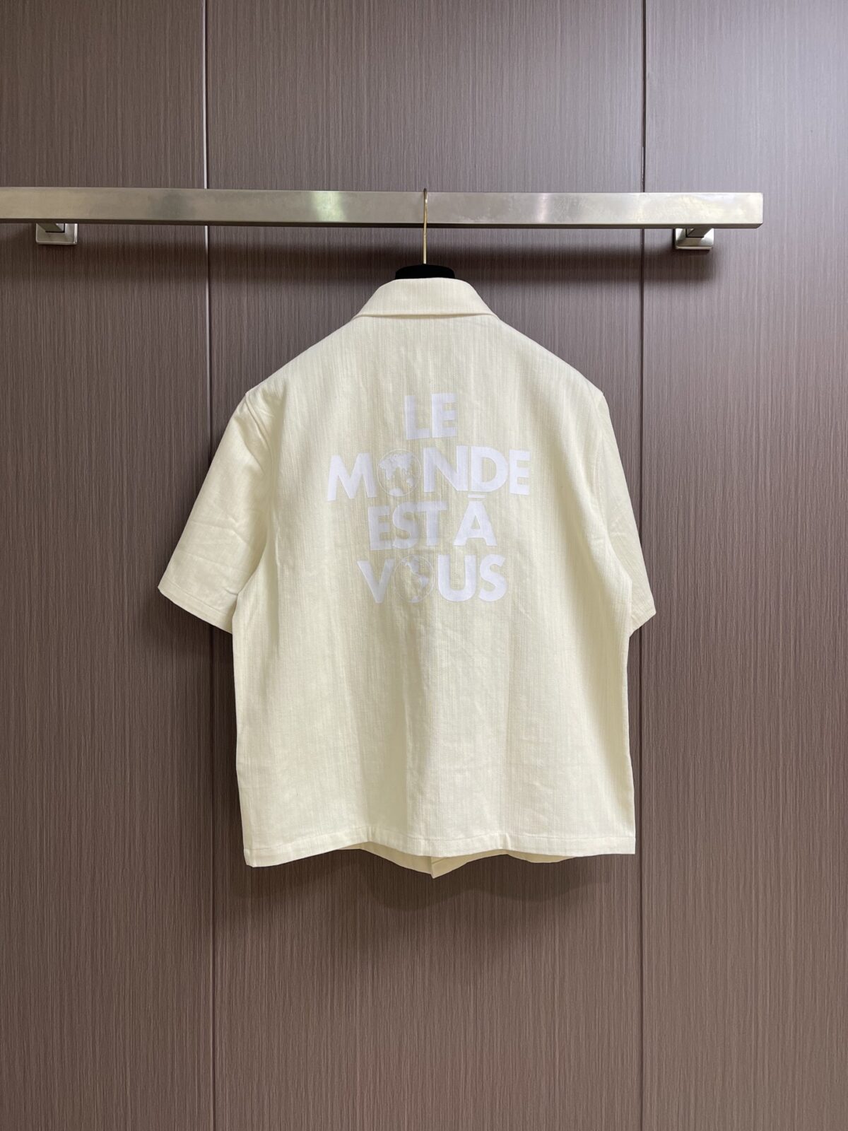 weigou_170816_1_383713a37d P215 LV 桑蚕丝混纺短袖衬衫,本品采用桑蚕丝混纺梭织面料,经预缩与抗皱处理,布面带有细腻竖条肌理,触感清凉顺滑,兼具蚕丝的亲肤透气与棉的挺括耐用,适配夏季穿着。经典翻领采用平车包边工艺,线条利落挺括,贴合颈部曲线;门襟采用金属纽扣设计,牢固耐用,开合顺畅。胸前贴袋搭配真皮皮标装饰,皮质温润细腻,压印标识精致考究;后背字母与标识采用胶印工艺,油墨饱满厚实,边缘清晰锐利,经多次水洗测试无开裂脱落风险。肩部与侧缝采用双线缝合,走线均匀细密,衣身采用宽松落肩剪裁,适配多元身形。成衣经过预洗定型,米白色调柔和干净,兼具轻奢格调与日常实用性,适配通勤、休闲等多种穿搭场景。整体走线平直细腻,面料舒适柔软,颜色一致无色差 能与同款搭配营造时尚造型,驾驭各种场合,定制辅料,三标齐全,男女同款!尺码:S-XL S码 衣长70 胸围118 肩宽50 袖长 M码 衣长 胸围122 肩宽51 袖长28 L码 衣长73 胸围126 肩宽52 袖长 XL码 衣长 胸围130 肩宽53 袖长29“”BB61