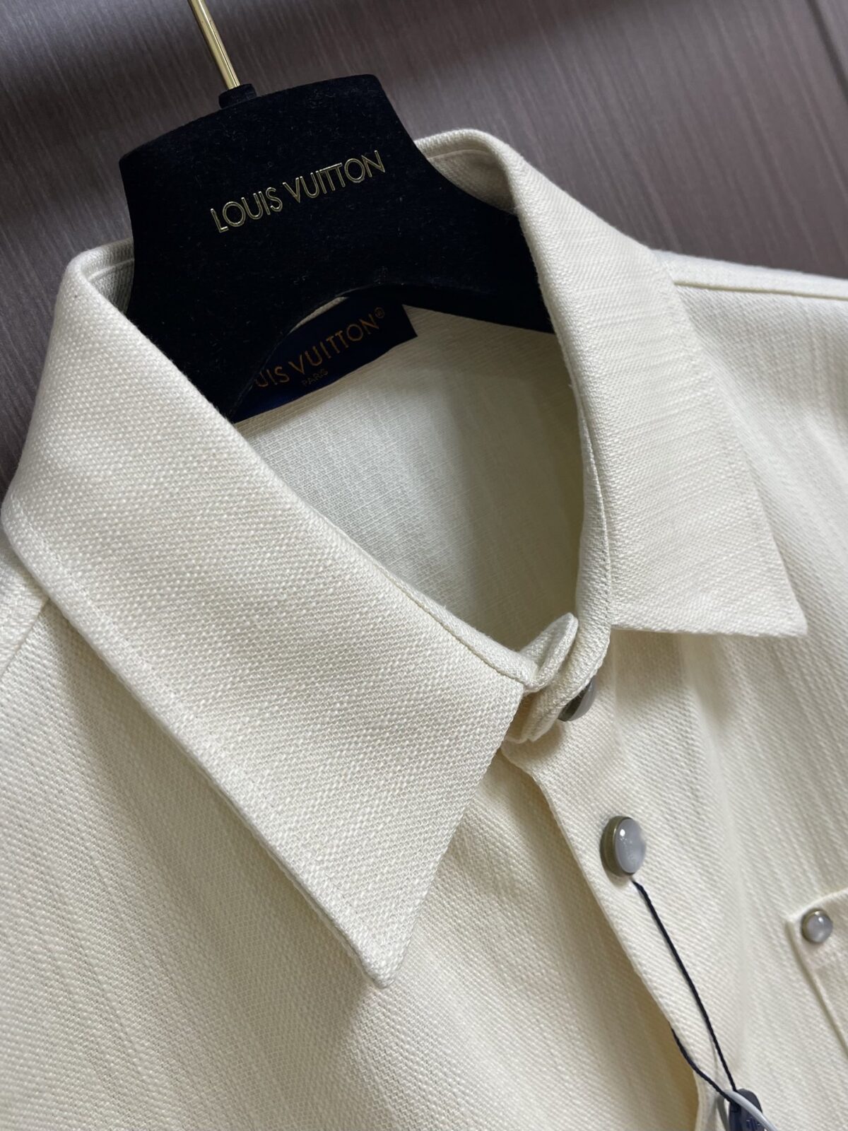 weigou_170816_2_26db818647 P215 LV 桑蚕丝混纺短袖衬衫,本品采用桑蚕丝混纺梭织面料,经预缩与抗皱处理,布面带有细腻竖条肌理,触感清凉顺滑,兼具蚕丝的亲肤透气与棉的挺括耐用,适配夏季穿着。经典翻领采用平车包边工艺,线条利落挺括,贴合颈部曲线;门襟采用金属纽扣设计,牢固耐用,开合顺畅。胸前贴袋搭配真皮皮标装饰,皮质温润细腻,压印标识精致考究;后背字母与标识采用胶印工艺,油墨饱满厚实,边缘清晰锐利,经多次水洗测试无开裂脱落风险。肩部与侧缝采用双线缝合,走线均匀细密,衣身采用宽松落肩剪裁,适配多元身形。成衣经过预洗定型,米白色调柔和干净,兼具轻奢格调与日常实用性,适配通勤、休闲等多种穿搭场景。整体走线平直细腻,面料舒适柔软,颜色一致无色差 能与同款搭配营造时尚造型,驾驭各种场合,定制辅料,三标齐全,男女同款!尺码:S-XL S码 衣长70 胸围118 肩宽50 袖长 M码 衣长 胸围122 肩宽51 袖长28 L码 衣长73 胸围126 肩宽52 袖长 XL码 衣长 胸围130 肩宽53 袖长29“”BB61