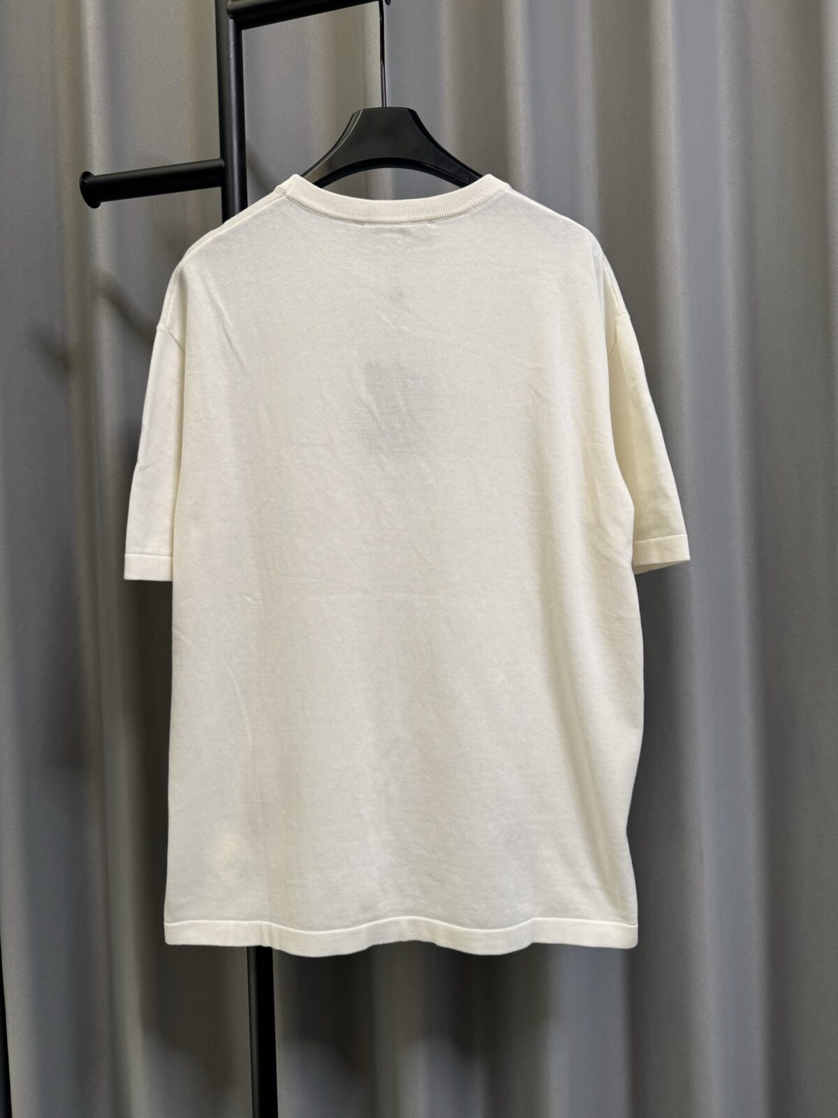 P155 【高端复刻】 𝐋𝐨𝐮𝐢𝐬 𝐕𝐮𝐢𝐭𝐭𝐨𝐧/路易 26SS lv手势刺绣针织短袖T恤（米白） LV 以趣味手势元素打造的创意系列短袖，用针织面料与立体刺绣工艺，打造兼具质感与个性的小众款。 🔹 面料与质感 核心面料：甄选LV 定制针织面料，布面细腻软糯，自带柔和哑光质感，上身轻薄透气，垂坠感优异，久穿不易起球变形。 穿着体验：面料亲肤透气，吸湿排汗性优异，夏季穿着清爽不闷汗；触感顺滑亲肤，不扎肤、不闷热，日常穿着舒适自在。 版型表现：合身直筒版型，修饰肩线与身形比例；圆领设计利落干练，自带简约高级氛围，适配多种穿搭场景。 🔹 工艺与细节 核心手势刺绣工艺： 胸口位置采用趣味手势刺绣，以藏蓝色为主体，搭配白色轮廓线，其中一只手上带有 LV 字母标识，刺绣针脚细密饱满，边缘无毛边，质感立体精致。在极简的米白色针织衣身上，这个创意手势刺绣是整件 T 恤的灵魂亮点。 细节做工： 领口采用罗纹收边，走线工整细密，反复穿着不易松垮变形； 袖口、下摆采用罗纹锁边，做工精细，不易脱线； 领标、洗水标等辅料齐全，完整还原正品配置，细节拉满。 Size：s/m/l/xl/