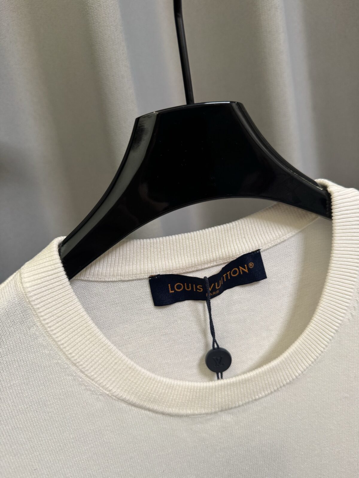 P155 【高端复刻】 𝐋𝐨𝐮𝐢𝐬 𝐕𝐮𝐢𝐭𝐭𝐨𝐧/路易 26SS lv手势刺绣针织短袖T恤（米白） LV 以趣味手势元素打造的创意系列短袖，用针织面料与立体刺绣工艺，打造兼具质感与个性的小众款。 🔹 面料与质感 核心面料：甄选LV 定制针织面料，布面细腻软糯，自带柔和哑光质感，上身轻薄透气，垂坠感优异，久穿不易起球变形。 穿着体验：面料亲肤透气，吸湿排汗性优异，夏季穿着清爽不闷汗；触感顺滑亲肤，不扎肤、不闷热，日常穿着舒适自在。 版型表现：合身直筒版型，修饰肩线与身形比例；圆领设计利落干练，自带简约高级氛围，适配多种穿搭场景。 🔹 工艺与细节 核心手势刺绣工艺： 胸口位置采用趣味手势刺绣，以藏蓝色为主体，搭配白色轮廓线，其中一只手上带有 LV 字母标识，刺绣针脚细密饱满，边缘无毛边，质感立体精致。在极简的米白色针织衣身上，这个创意手势刺绣是整件 T 恤的灵魂亮点。 细节做工： 领口采用罗纹收边，走线工整细密，反复穿着不易松垮变形； 袖口、下摆采用罗纹锁边，做工精细，不易脱线； 领标、洗水标等辅料齐全，完整还原正品配置，细节拉满。 Size：s/m/l/xl/