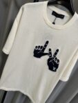 P155 【高端复刻】 𝐋𝐨𝐮𝐢𝐬 𝐕𝐮𝐢𝐭𝐭𝐨𝐧/路易 26SS lv手势刺绣针织短袖T恤（米白） LV 以趣味手势元素打造的创意系列短袖，用针织面料与立体刺绣工艺，打造兼具质感与个性的小众款。 🔹 面料与质感 核心面料：甄选LV 定制针织面料，布面细腻软糯，自带柔和哑光质感，上身轻薄透气，垂坠感优异，久穿不易起球变形。 穿着体验：面料亲肤透气，吸湿排汗性优异，夏季穿着清爽不闷汗；触感顺滑亲肤，不扎肤、不闷热，日常穿着舒适自在。 版型表现：合身直筒版型，修饰肩线与身形比例；圆领设计利落干练，自带简约高级氛围，适配多种穿搭场景。 🔹 工艺与细节 核心手势刺绣工艺： 胸口位置采用趣味手势刺绣，以藏蓝色为主体，搭配白色轮廓线，其中一只手上带有 LV 字母标识，刺绣针脚细密饱满，边缘无毛边，质感立体精致。在极简的米白色针织衣身上，这个创意手势刺绣是整件 T 恤的灵魂亮点。 细节做工： 领口采用罗纹收边，走线工整细密，反复穿着不易松垮变形； 袖口、下摆采用罗纹锁边，做工精细，不易脱线； 领标、洗水标等辅料齐全，完整还原正品配置，细节拉满。 Size：s/m/l/xl/