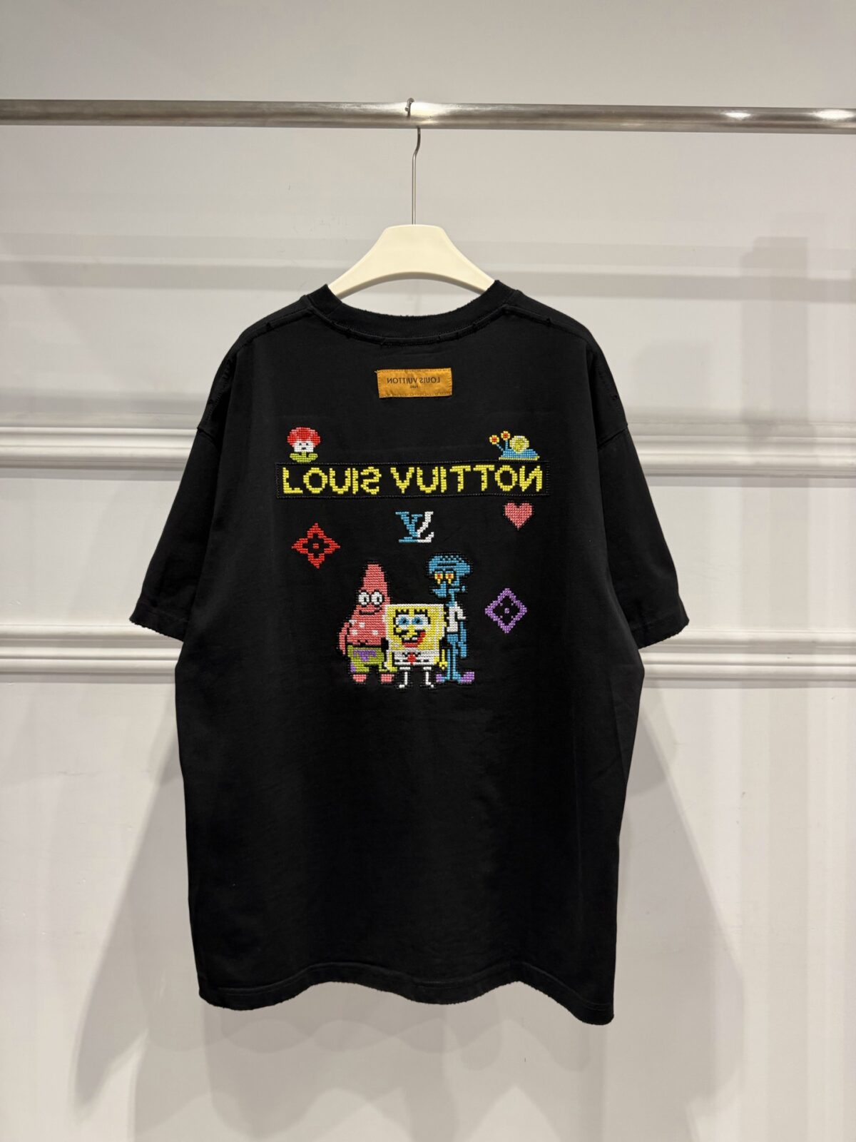 weigou_174587_3_015dafa1bb P85 路易威登 LOUIS VUITTON × 海绵宝宝像素风刺绣联名限定T恤做旧圆领短袖 高品质 高工艺 细节拉满 经典重塑潮奢格调,正面海绵宝宝刺绣搭配LV品牌标识,趣味又吸睛;背面像素风派大星、章鱼哥组合印花,叠加LV Monogram元素,将童年回忆与奢侈美学完美融合。 甄选320克重磅纯棉面料,宽松落肩剪裁适配多元身形,磨边做旧工艺上身自带松弛街头感。不管是搭配牛仔裤打造日常出街造型,还是叠穿打造高街风,都能轻松拿捏。限量联名款自带收藏属性,是潮人衣橱里的刚需单品,轻松穿出专属个性态度。 尺码:S—XL 颜色:黑色 白色