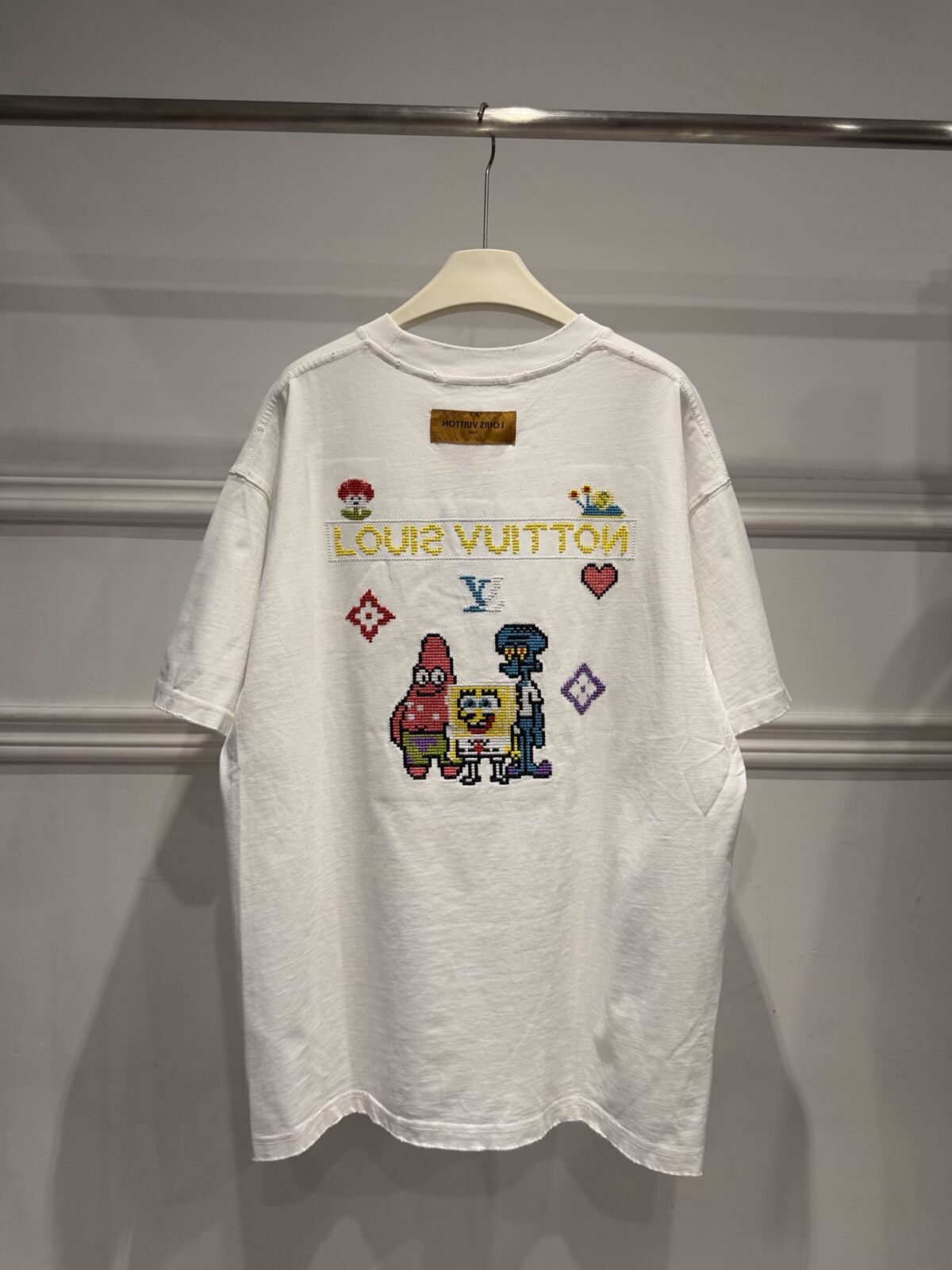 weigou_174587_4_f78ba86e6c P85 路易威登 LOUIS VUITTON × 海绵宝宝像素风刺绣联名限定T恤做旧圆领短袖 高品质 高工艺 细节拉满 经典重塑潮奢格调,正面海绵宝宝刺绣搭配LV品牌标识,趣味又吸睛;背面像素风派大星、章鱼哥组合印花,叠加LV Monogram元素,将童年回忆与奢侈美学完美融合。 甄选320克重磅纯棉面料,宽松落肩剪裁适配多元身形,磨边做旧工艺上身自带松弛街头感。不管是搭配牛仔裤打造日常出街造型,还是叠穿打造高街风,都能轻松拿捏。限量联名款自带收藏属性,是潮人衣橱里的刚需单品,轻松穿出专属个性态度。 尺码:S—XL 颜色:黑色 白色