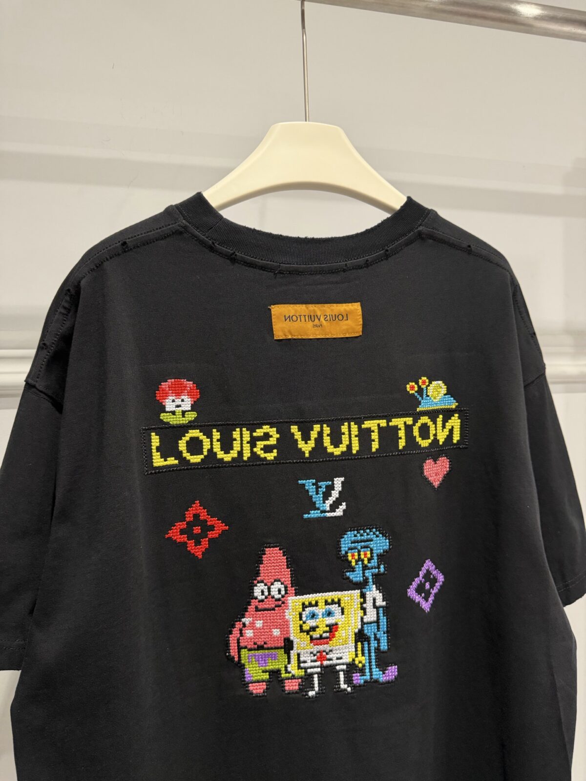 weigou_174587_6_659b9f41c3 P85 路易威登 LOUIS VUITTON × 海绵宝宝像素风刺绣联名限定T恤做旧圆领短袖 高品质 高工艺 细节拉满 经典重塑潮奢格调,正面海绵宝宝刺绣搭配LV品牌标识,趣味又吸睛;背面像素风派大星、章鱼哥组合印花,叠加LV Monogram元素,将童年回忆与奢侈美学完美融合。 甄选320克重磅纯棉面料,宽松落肩剪裁适配多元身形,磨边做旧工艺上身自带松弛街头感。不管是搭配牛仔裤打造日常出街造型,还是叠穿打造高街风,都能轻松拿捏。限量联名款自带收藏属性,是潮人衣橱里的刚需单品,轻松穿出专属个性态度。 尺码:S—XL 颜色:黑色 白色