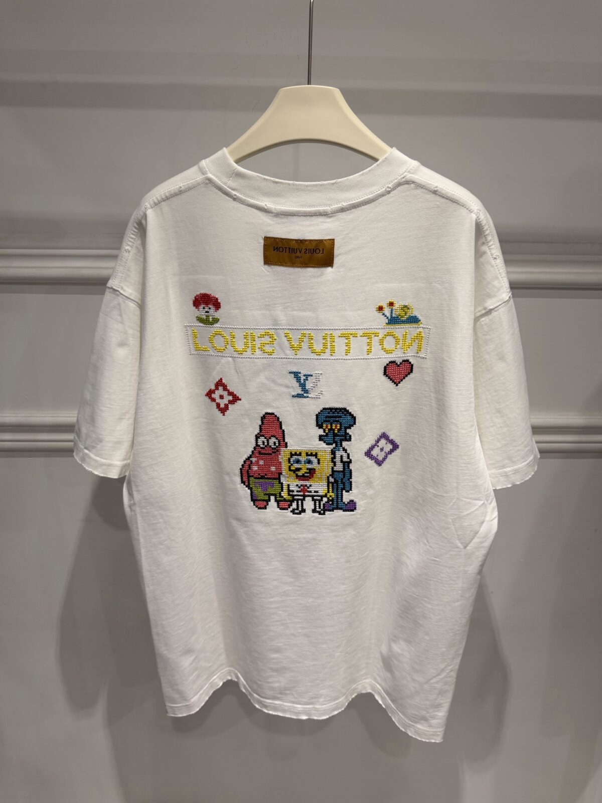 weigou_174587_9_26d99ee9c8 P85 路易威登 LOUIS VUITTON × 海绵宝宝像素风刺绣联名限定T恤做旧圆领短袖 高品质 高工艺 细节拉满 经典重塑潮奢格调,正面海绵宝宝刺绣搭配LV品牌标识,趣味又吸睛;背面像素风派大星、章鱼哥组合印花,叠加LV Monogram元素,将童年回忆与奢侈美学完美融合。 甄选320克重磅纯棉面料,宽松落肩剪裁适配多元身形,磨边做旧工艺上身自带松弛街头感。不管是搭配牛仔裤打造日常出街造型,还是叠穿打造高街风,都能轻松拿捏。限量联名款自带收藏属性,是潮人衣橱里的刚需单品,轻松穿出专属个性态度。 尺码:S—XL 颜色:黑色 白色