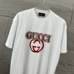 weigou_175900_1_8cfb14bc25 P80 Gu* 古驰* 2026春夏新款 双G胸前Gucci字母. 植绒工艺 短袖T恤 定制双纱平纹纯棉面料 男女同款 颜色:黑色 白色 杏色 尺码: S (90-130斤) M (120-150斤) L (140-165斤) XL (160-180斤) XXL (180-210斤)