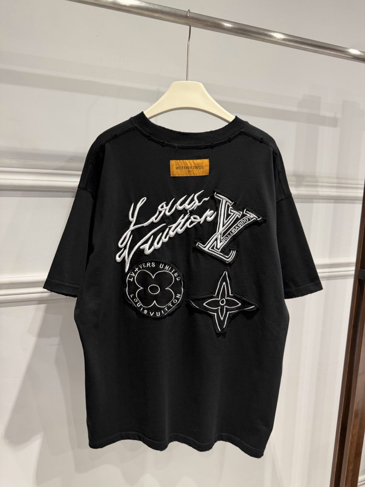 P80 Louis Vuitton路易威登LV新款涂鸦重工刺绣短袖做旧T恤 这件路易威登将品牌经典老花元素以涂鸦风刺绣重新演绎，自带街头潮流气场。正面低调的四叶花刺绣暗藏巧思，背面则是手写体品牌标识与多种Monogram图腾的组合刺绣层次丰富 磨破做旧工艺又个性吸睛。 甄选320高克重纯棉面料，触感柔软亲肤，上身垂坠有型，久穿也不易变形。宽松落肩版型对身材包容性极强，男女同款适配情侣穿搭，搭配工装裤、破洞牛仔或阔腿卫裤都超有范儿。 作为衣橱里的“百搭王”，它既能驾驭日常出街，也能撑起潮酷造型，是兼顾质感与个性的高阶潮流单品，懂的朋友别错过！ 尺码：S—XL 颜色：黑色 白色