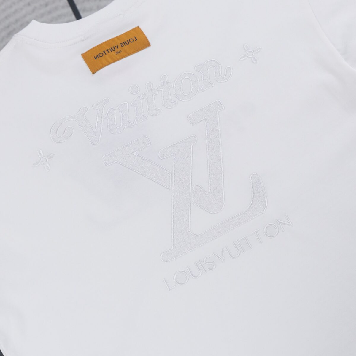 weigou_180057_3_7e9a95b990 P70 Louis Vuitton路易威登LV2026新款浮雕刺绣宽松短袖圆领T恤 甄选高克重重磅纯棉面料,触感细腻厚实,久洗不易变形。极简纯白底色搭配同色系立体浮雕刺绣,正面简约手写Logo低调内敛,背面放大LV标识辅以星芒点缀,暗纹工艺高级克制,拒绝浮夸撞款。 宽松落肩版型不挑身材,男女同款适配多种搭配,单穿清爽干净,叠搭牛仔外套、机能夹克皆出彩。领口加固包边不易松垮,后背品牌黄色织标提升细节质感。轻奢低调的街头格调,日常通勤、潮流出街皆适配,衣柜百搭典藏基础款。 颜色:黑色 白色 尺码:S—XL