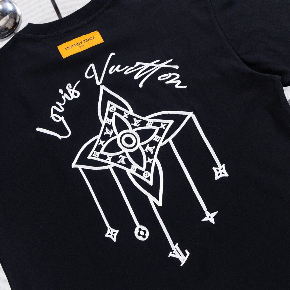 weigou_180114_4_b09f787322 P70 路易威登Louis Vuitton 26ss新款流苏老花刺绣T恤圆领短袖 这件路易威登双面刺绣T采用高克重纯棉面料,触感柔软透气,上身垂坠有型。正面以刺绣勾勒品牌经典四叶花图腾,低调精致;背面则是手绘风LV标识与放大版流苏式Monogram刺绣,街头感十足。宽松落肩版型不挑身形,男女同款,上身透气舒适,久穿不易变形。宽松落肩版型对各种身材都很友好,搭配牛仔裤、工装裤都能轻松出片。男女同款,情侣穿也超有格调,是能提升穿搭质感的宝藏款,懂的朋友别错过! 尺码:S—XL 颜色:黑色 白色