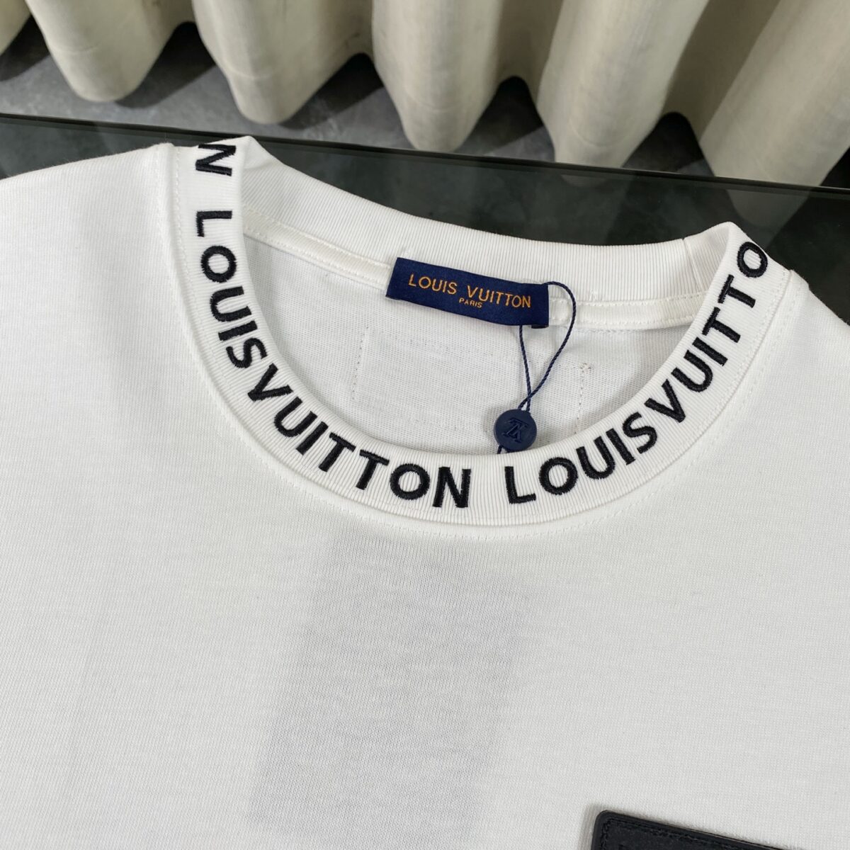 P75 LOUIS VUITTON/路易威登LV 2025夏季新款皮标贴袋领口经典字母刺绣短袖圆领T恤 面料采用320G 100%纯棉双纱面料 同缸定染特种加粗32支双股1X1螺纹克纯棉面料，保证舒适性同时透气冰爽的同时又不透底！面料上身有型弹性不紧绷日常通勤运动统统yyds 肩膀采用双针车线跨缝工艺后领口处采用纯棉拉条提升了后颈接触的舒适度布面干净.布纹清晰，柔软舒适 - 全套定制的原版辅料，吊牌，洗水，主唛，防潮纸统统安排到位。版型釆用OS宽松落肩版型.男女同款 Louis Vuitton，法国路威酩轩集团-LVMH旗下品牌，著名奢侈品箱包和皮具品牌，百余年的传奇经典，全球时尚旅行艺术的精致象征。印有“LV”标志这一独特图案的交织字母帆布包，伴随着丰富的传奇色彩和雅典的设计而成为时尚之经典。延续至今，不论后来延伸出来的皮件、丝巾或手表、笔、服装，都是以崇尚精致、品质、舒适的“旅行哲学”，作为设计理念。 颜色：黑色 白色 Size: S-XL
