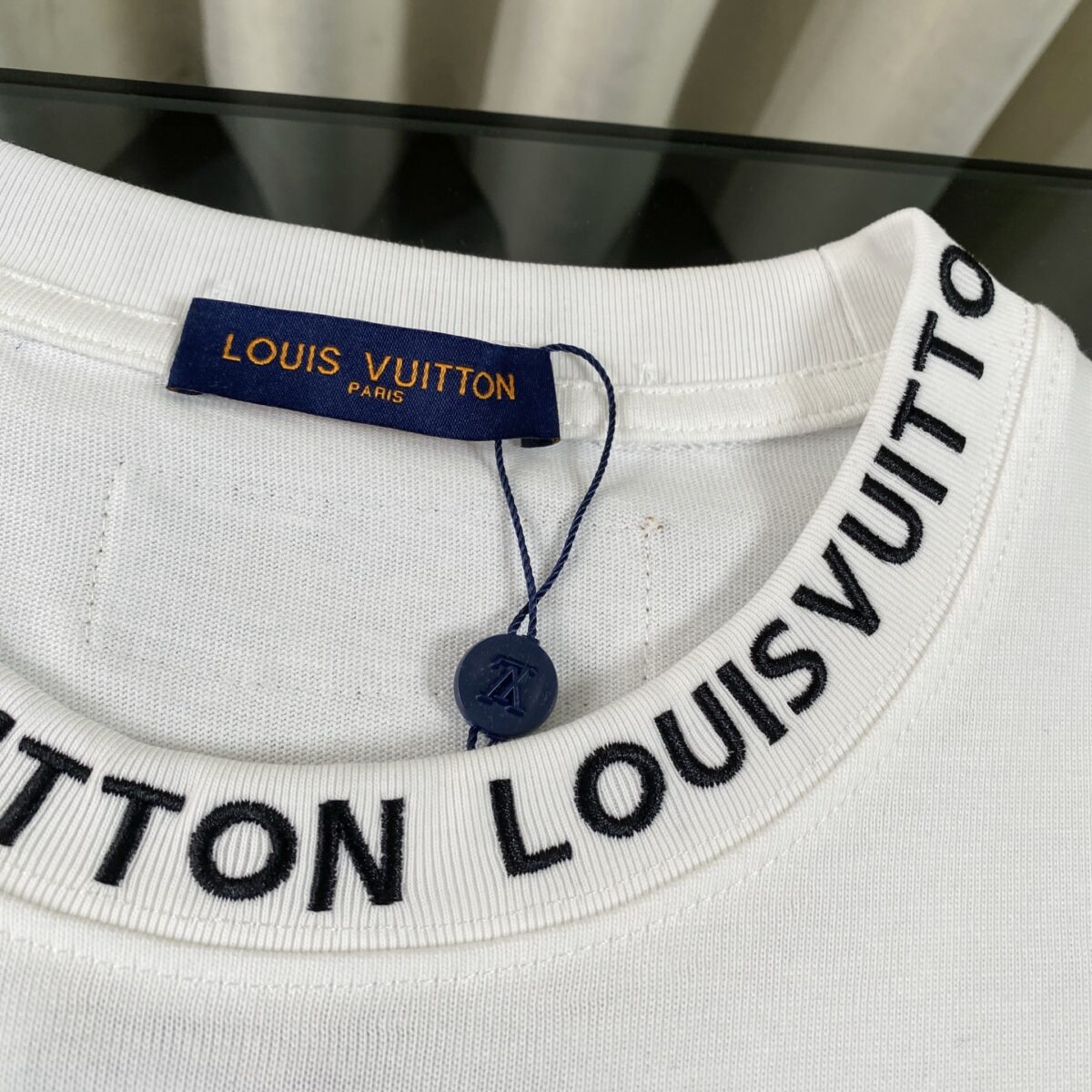 P75 LOUIS VUITTON/路易威登LV 2025夏季新款皮标贴袋领口经典字母刺绣短袖圆领T恤 面料采用320G 100%纯棉双纱面料 同缸定染特种加粗32支双股1X1螺纹克纯棉面料，保证舒适性同时透气冰爽的同时又不透底！面料上身有型弹性不紧绷日常通勤运动统统yyds 肩膀采用双针车线跨缝工艺后领口处采用纯棉拉条提升了后颈接触的舒适度布面干净.布纹清晰，柔软舒适 - 全套定制的原版辅料，吊牌，洗水，主唛，防潮纸统统安排到位。版型釆用OS宽松落肩版型.男女同款 Louis Vuitton，法国路威酩轩集团-LVMH旗下品牌，著名奢侈品箱包和皮具品牌，百余年的传奇经典，全球时尚旅行艺术的精致象征。印有“LV”标志这一独特图案的交织字母帆布包，伴随着丰富的传奇色彩和雅典的设计而成为时尚之经典。延续至今，不论后来延伸出来的皮件、丝巾或手表、笔、服装，都是以崇尚精致、品质、舒适的“旅行哲学”，作为设计理念。 颜色：黑色 白色 Size: S-XL