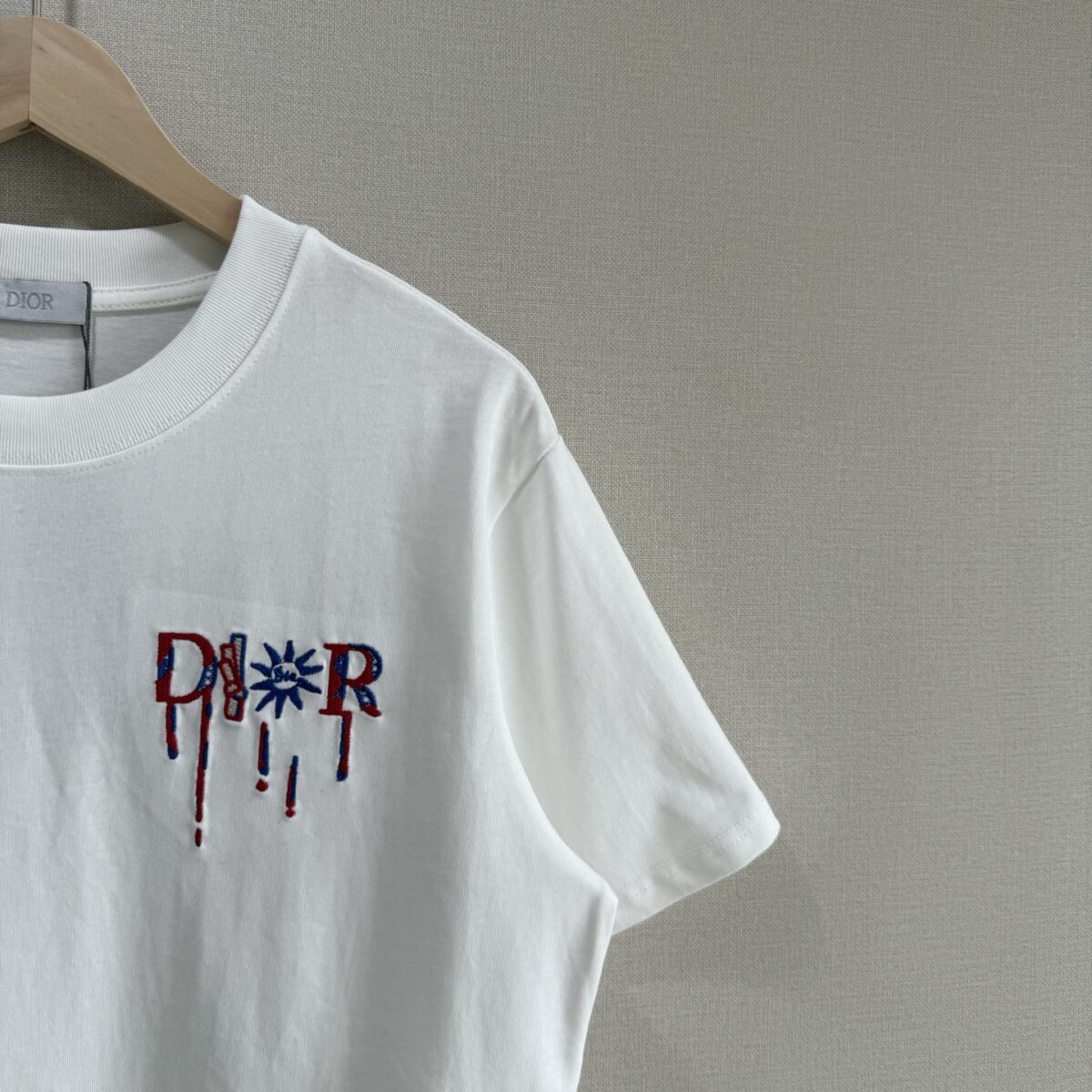 P75 款号TM1068 Dior 迪奥红标涂鸦太阳刺绣圆领短袖 面料：280克32支双纱纯棉面料 工艺：重工精梳棉 螺纹同缸同色 整体不会有色差 当下热度爆款 男女情侣款 定制原版一致辅料 三标齐全 os宽松版型 最大可穿到200斤左右 颜色：黑色 白色 尺码：S M L XL
