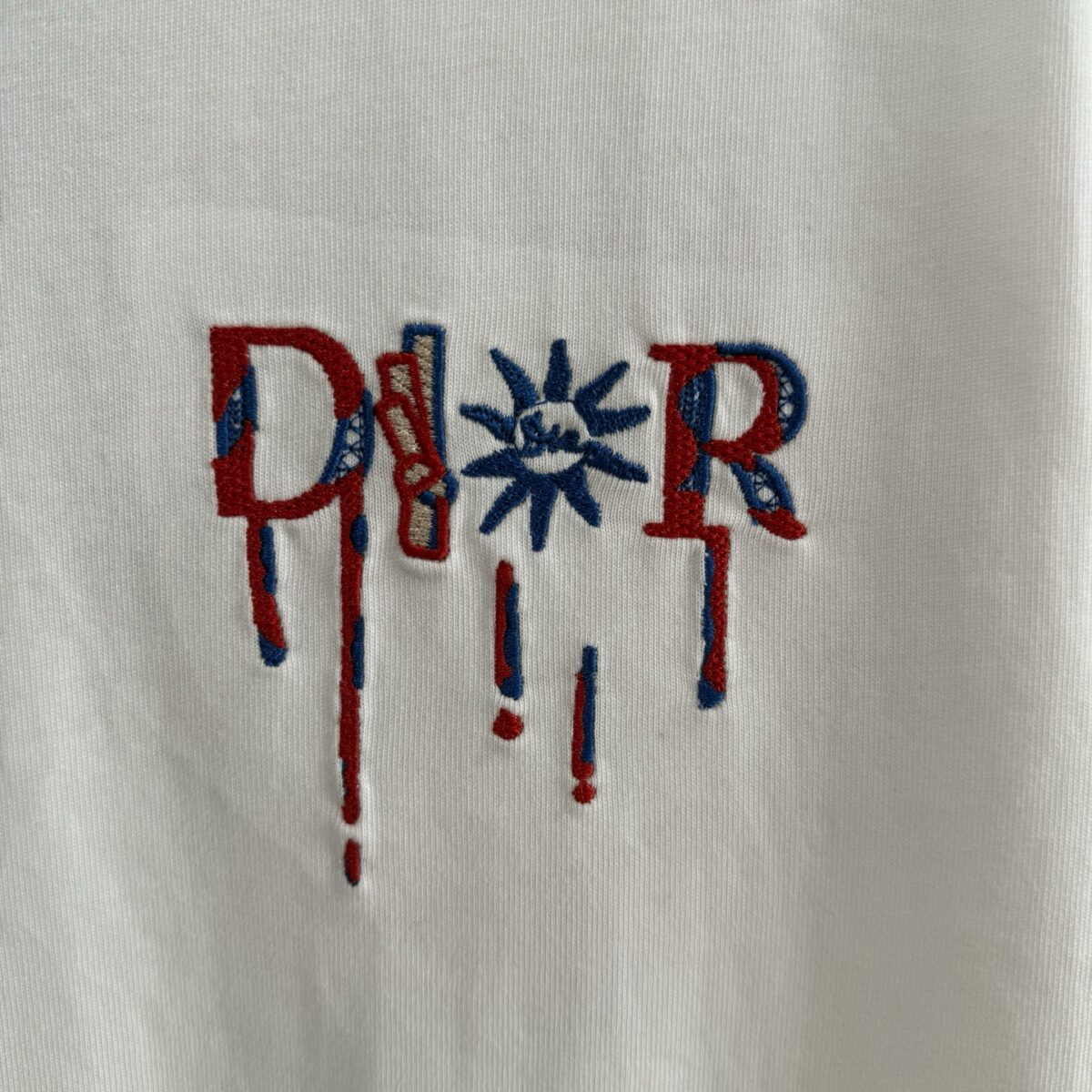 P75 款号TM1068 Dior 迪奥红标涂鸦太阳刺绣圆领短袖 面料：280克32支双纱纯棉面料 工艺：重工精梳棉 螺纹同缸同色 整体不会有色差 当下热度爆款 男女情侣款 定制原版一致辅料 三标齐全 os宽松版型 最大可穿到200斤左右 颜色：黑色 白色 尺码：S M L XL