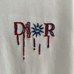 P75 款号TM1068 Dior 迪奥红标涂鸦太阳刺绣圆领短袖 面料：280克32支双纱纯棉面料 工艺：重工精梳棉 螺纹同缸同色 整体不会有色差 当下热度爆款 男女情侣款 定制原版一致辅料 三标齐全 os宽松版型 最大可穿到200斤左右 颜色：黑色 白色 尺码：S M L XL