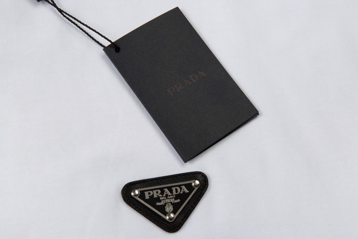 P65 Prada 普拉达 2026ss 春夏新款首发最新款短袖圆领T恤 高端订制 设计前卫时尚！品牌logo重工艺设计 高端定制320克双纱纯棉面料.手感柔软.穿着舒适.级别精致车线.做工精细.上身效果无敌帅气！型男必备单品！ 颜色：黑色 白色 码数：S- XL