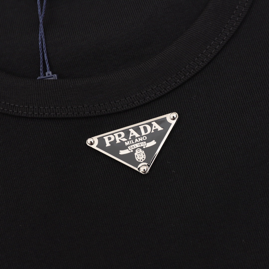 P65 PRADA普拉达2026ss新款胸前三角标情侣休闲短袖T恤 👑最高版本！280克、32支双纱面料！定制经典三角标！ 辅料：开模原版过鉴定领标➕100%真丝洗水标。正品代购级原版吊牌➕配套吊绳➕3D吊粒➕原版包装袋 工艺：原版一致走线！袖窿对版手法 最高版本！无数次的打版 百分百还原正品品相！ 正确版本 男女同款 超级显眼 超级好看 超级大气！ 颜色：黑色 白色 尺码：Xs-L