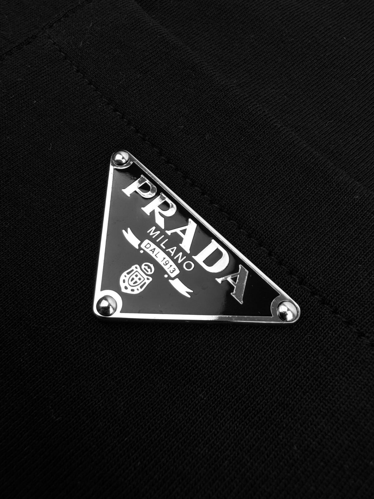 P80 Prada 普拉达口袋三角标短袖 定制丝韵柔滑棉平纹绸 透气清爽 舒适贴肤 沉醉于黑色的深邃 标志性Prada三角标点缀胸前 彰显品牌魅力 加以口袋设计巧妙融合 口袋风情散发独特魅力 以极简设计 震撼你的视觉 以低调的姿态彰显奢华 工艺1：采用进口专机红外线定位“Prada三角标” 位置更为精准 牢固结实 工艺2: 面料都经过浇洗 手感质感更佳 不易变形 不易缩水 不易褪色 保持长久的美观 辅料：定制1:1 Prada涂珐琅金属三角形 定制1:1 Prada商标 版型： 宽松版型 尺码： XS S M L