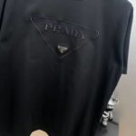 P80 Prad～普拉刺绣大三角盾牌字母 《区别通货面料》 双纱纯棉紧密纱线短袖tee 上身十分舒适，男女同款半袖，落肩宽松版型 颜色: 黑色 白色 咖啡色 尺码：S（90-130斤） M（125-150斤） L（135-165斤） XL（160-190斤） XXL（185-220斤）