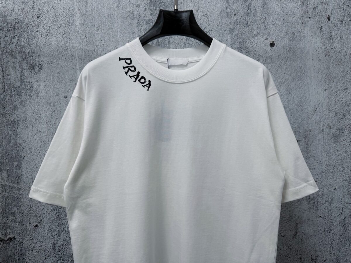 P70 【PRADA】普拉达26SS经典植绒印花字母短袖T恤男女同款 采用顶级280克定制双纱纯棉面料质感非常柔软舒服 搭配320克1x1螺纹(面料螺纹同缸定染无色差不易变形)定制 领标洗水唛吊牌 包装🎗 os落肩宽松版型春夏最新砖柜同步男女同款 颜色:黑色，白色 尺码：XS-L