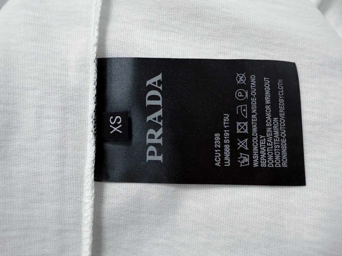 P70 【PRADA】普拉达26SS经典植绒印花字母短袖T恤男女同款 采用顶级280克定制双纱纯棉面料质感非常柔软舒服 搭配320克1x1螺纹(面料螺纹同缸定染无色差不易变形)定制 领标洗水唛吊牌 包装🎗 os落肩宽松版型春夏最新砖柜同步男女同款 颜色:黑色，白色 尺码：XS-L