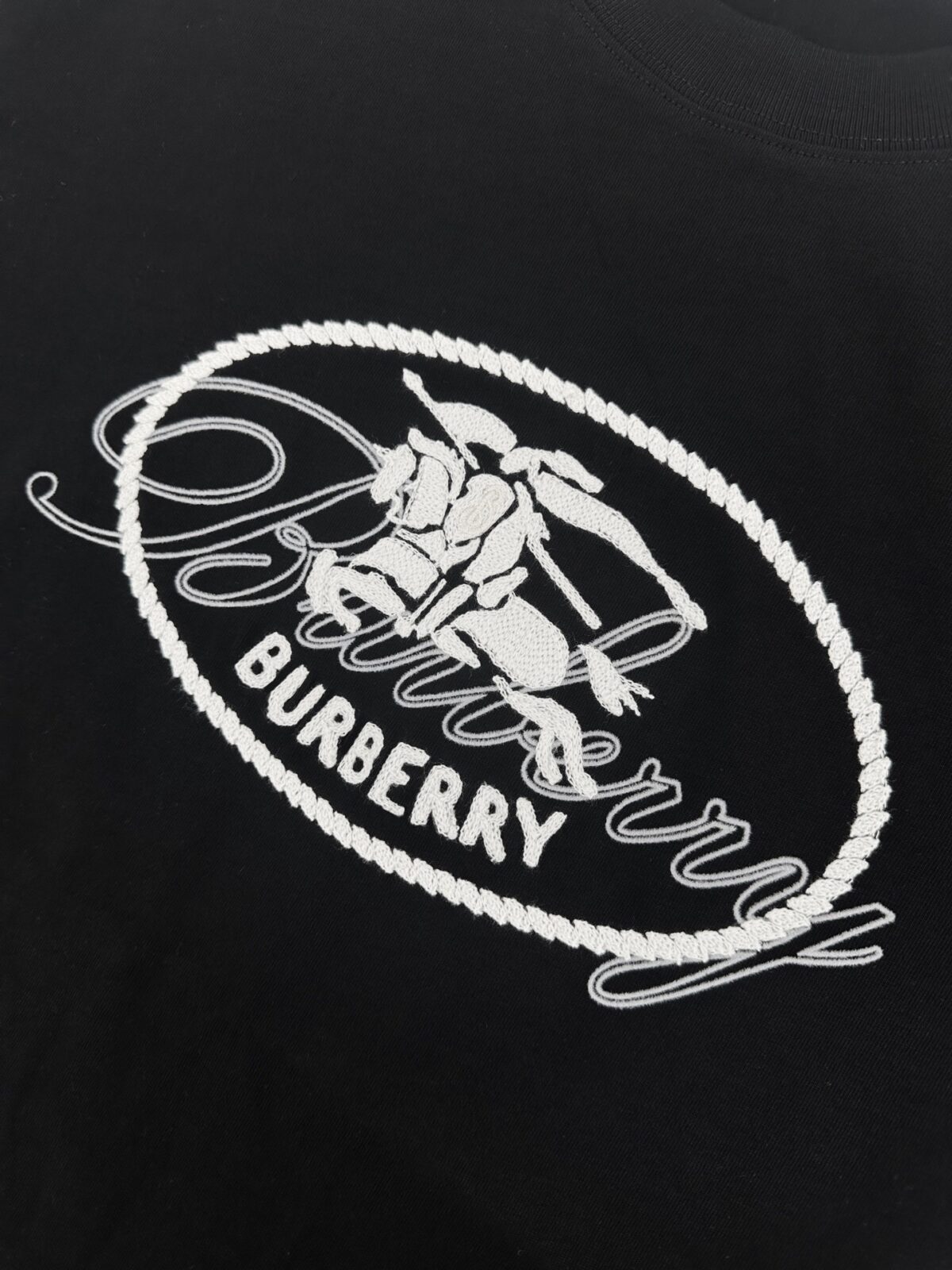 P75 款号:mm131 Burberry巴宝莉 26ss新款植绒字母毛巾绣T恤衫短袖，面料选用300克平织棉面料打造，呈现常规版型。圆领款式，点缀植绒品牌徽标印花。采用链式缝线刺绣工艺，铺叠骑士印章装饰，源自 1980 年代品牌包款的典藏图案。 颜色:黑色 白色 码数：S. M. L. XL