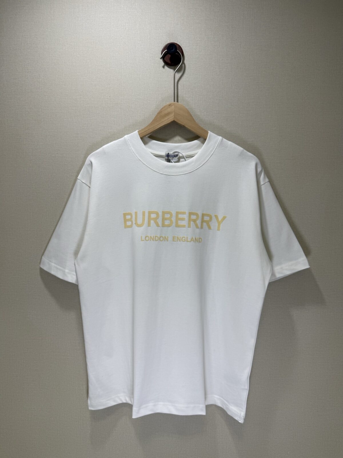 P70 款号TM1108 BURBERRY 巴宝莉新款限定高级植绒金标圆领短袖 面料：280 克32支双纱纯棉面料 工艺：重工精梳棉 螺纹同缸同色 整体不会有色差 当下热度爆款 男女情侣款 定制原版一致辅料 三标齐全 os宽松版型 最大可穿到200斤左右 颜色：白色 黑色 尺码：S M L XL