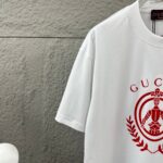 weigou_207091_2_2011049e02 P75 Gu* 古驰* 2026春夏新款 双G胸前Gucci字母. 植绒工艺 短袖T恤 定制双纱平纹纯棉面料 男女同款 颜色:黑色 白色 尺码: S (90-130斤) M (120-150斤) L (140-165斤) XL (160-180斤) XXL (180-210斤)