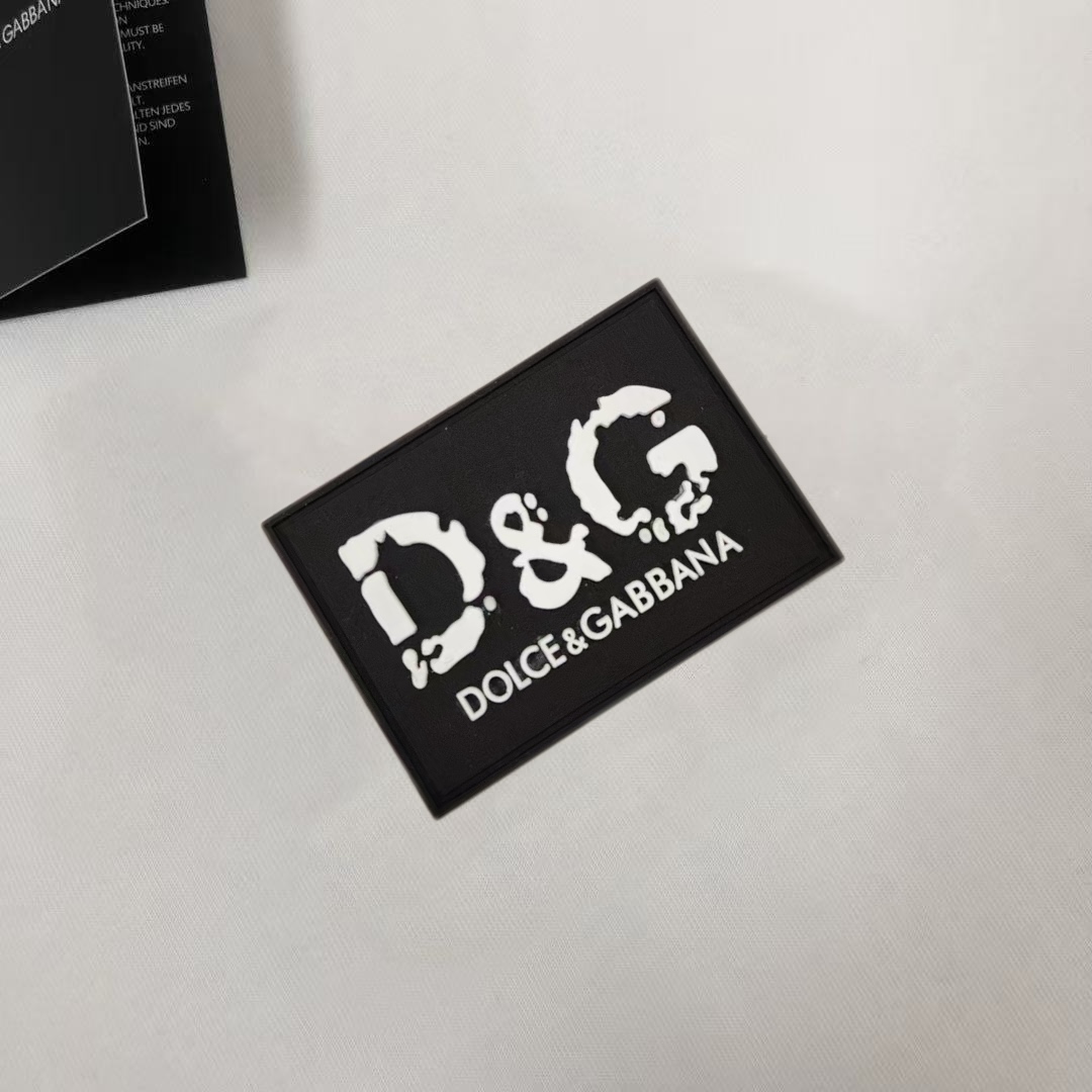 P75 Dolce&gabbana 专柜同款圆领短袖T恤 定制棉质面料 ！采用品牌DG Logo标志皮牌设计！ 立体感强！使整体高透气和柔软性的质感更加凸显，饱满的棉质感引起极度舒适。高端人士必备单品，原厂辅料三标齐全！男女同款！ 颜色：黑色 白色 尺码：S-xxL