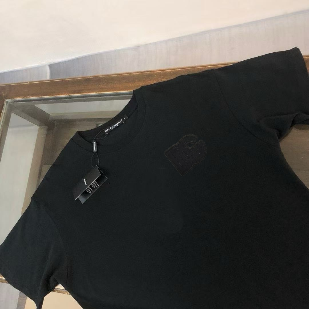 P75 Dolce&gabbana 专柜同款圆领短袖T恤 定制棉质面料 ！采用品牌DG Logo标志皮牌设计！ 立体感强！使整体高透气和柔软性的质感更加凸显，饱满的棉质感引起极度舒适。高端人士必备单品，原厂辅料三标齐全！男女同款！ 颜色：黑色 白色 尺码：S-xxL