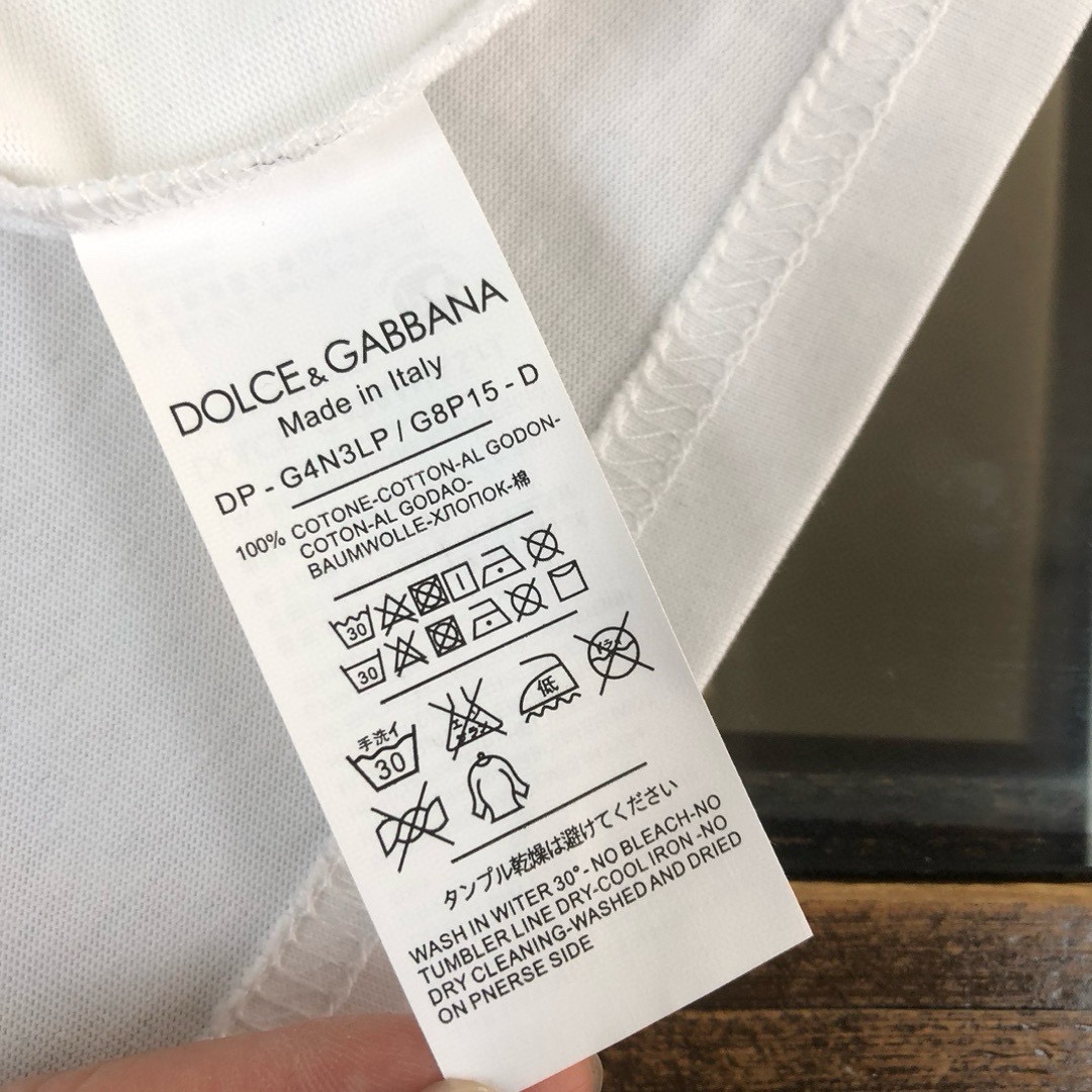 P75 Dolce&gabbana 专柜同款圆领短袖T恤 定制棉质面料 ！采用品牌DG Logo标志皮牌设计！ 立体感强！使整体高透气和柔软性的质感更加凸显，饱满的棉质感引起极度舒适。高端人士必备单品，原厂辅料三标齐全！男女同款！ 颜色：黑色 白色 尺码：S-xxL
