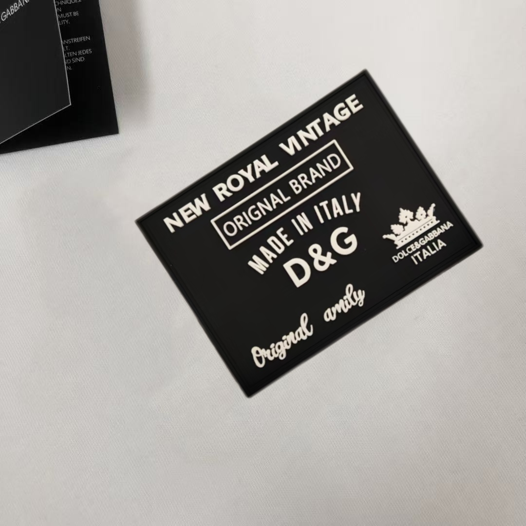 P75 Dolce&gabbana 专柜同款圆领短袖T恤 定制棉质面料 ！采用品牌DG Logo标志皮牌设计！ 立体感强！使整体高透气和柔软性的质感更加凸显，饱满的棉质感引起极度舒适。高端人士必备单品，原厂辅料三标齐全！男女同款！ 颜色：黑色 白色 尺码：S-xxL