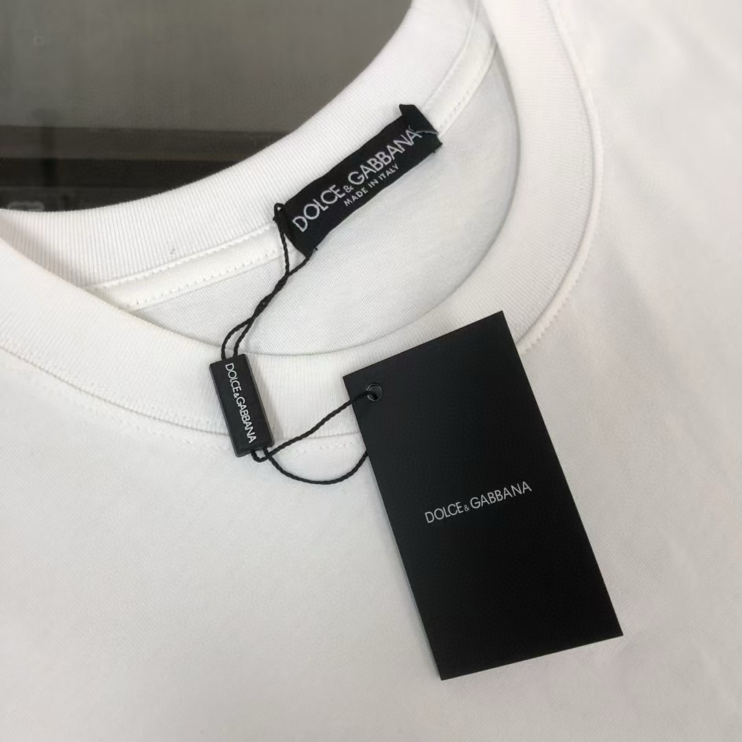 P75 Dolce&gabbana 专柜同款圆领短袖T恤 定制棉质面料 ！采用品牌DG Logo标志五金皮牌设计！ 立体感强！使整体高透气和柔软性的质感更加凸显，饱满的棉质感引起极度舒适。高端人士必备单品，原厂辅料三标齐全！男女同款！ 颜色：黑色 白色 尺码：S-xxL