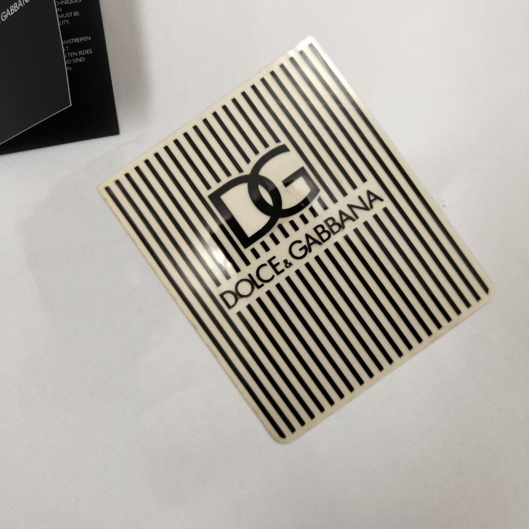 P75 Dolce&gabbana 专柜同款圆领短袖T恤 定制棉质面料 ！采用品牌DG Logo标志硅胶设计！ 立体感强！使整体高透气和柔软性的质感更加凸显，饱满的棉质感引起极度舒适。高端人士必备单品，原厂辅料三标齐全！男女同款！ 颜色：黑色 白色 尺码：S-xxL