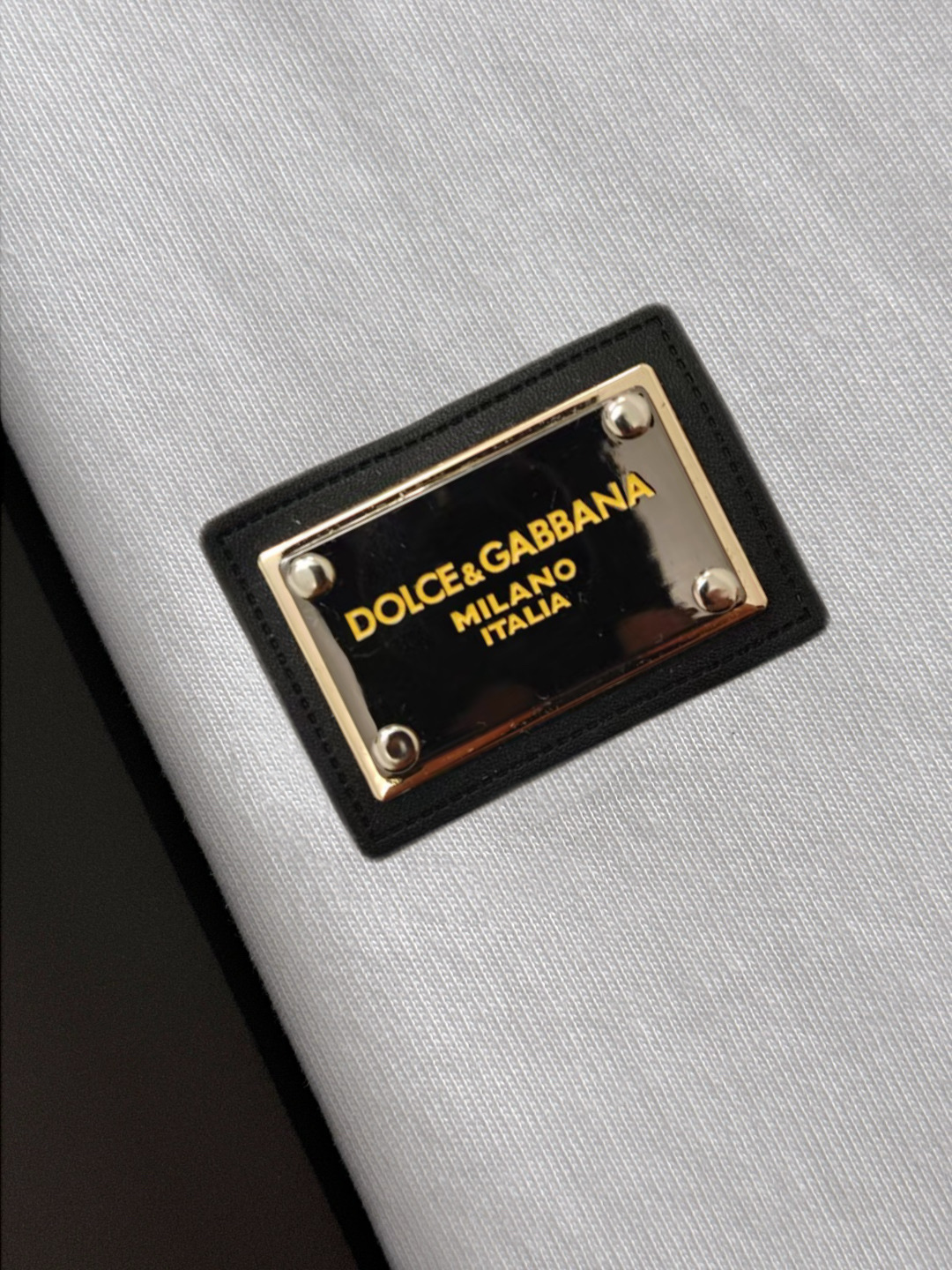 P75 Dolce&gabbana 专柜同款圆领短袖T恤 定制棉质面料 ！采用品牌DG Logo标志皮牌设计！ 立体感强！使整体高透气和柔软性的质感更加凸显，饱满的棉质感引起极度舒适。高端人士必备单品，原厂辅料三标齐全！男女同款！ 颜色：黑色 白色 尺码：S-xxL