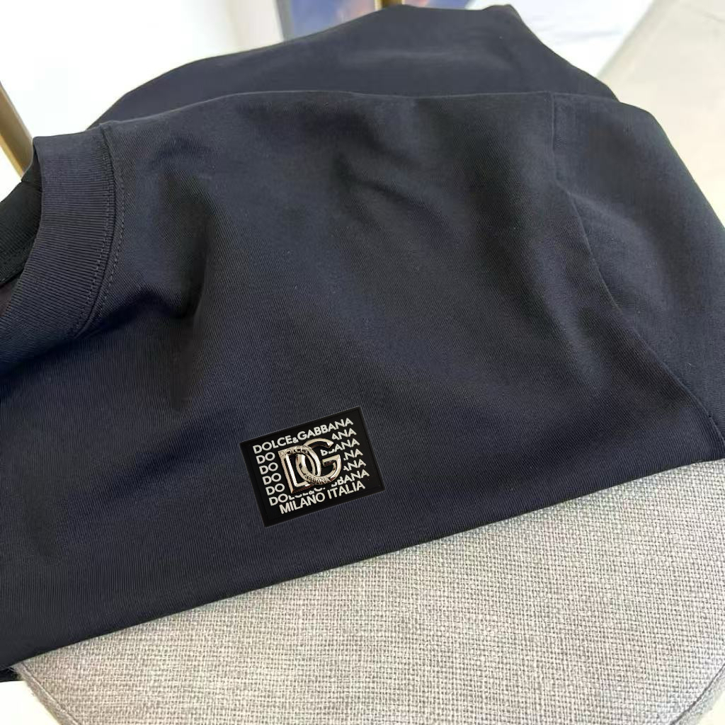 P75 DG 2026春夏新品经典短袖T恤，延续品牌标志性的简约美学与法式松弛感，以纯色为底色，左胸点缀小巧精致刺绣，精致不张扬，诠释低调高级的都市格调。宽松廓形剪裁，落肩设计搭配微阔下摆，包容各种身形，营造随性自在的穿着体验，无论是单穿还是叠搭皆能轻松驾驭。面料甄选高支棉质，触感柔软亲肤，透气性佳，适合春夏日常通勤、周末出游或轻社交场合。极简线条与自然垂坠感赋予衣身流动韵律，细节处彰显匠心工艺，下摆保留原厂吊牌，传递新品首发质感。这款T恤不仅是衣橱基础款，更是风格表达的点睛之笔——不喧哗，自有声。2026春夏，让爱与自由在衣襟间悄然绽放，穿出属于你的温柔力量与都市从容。S- XXL（模特173，140斤上身M码）