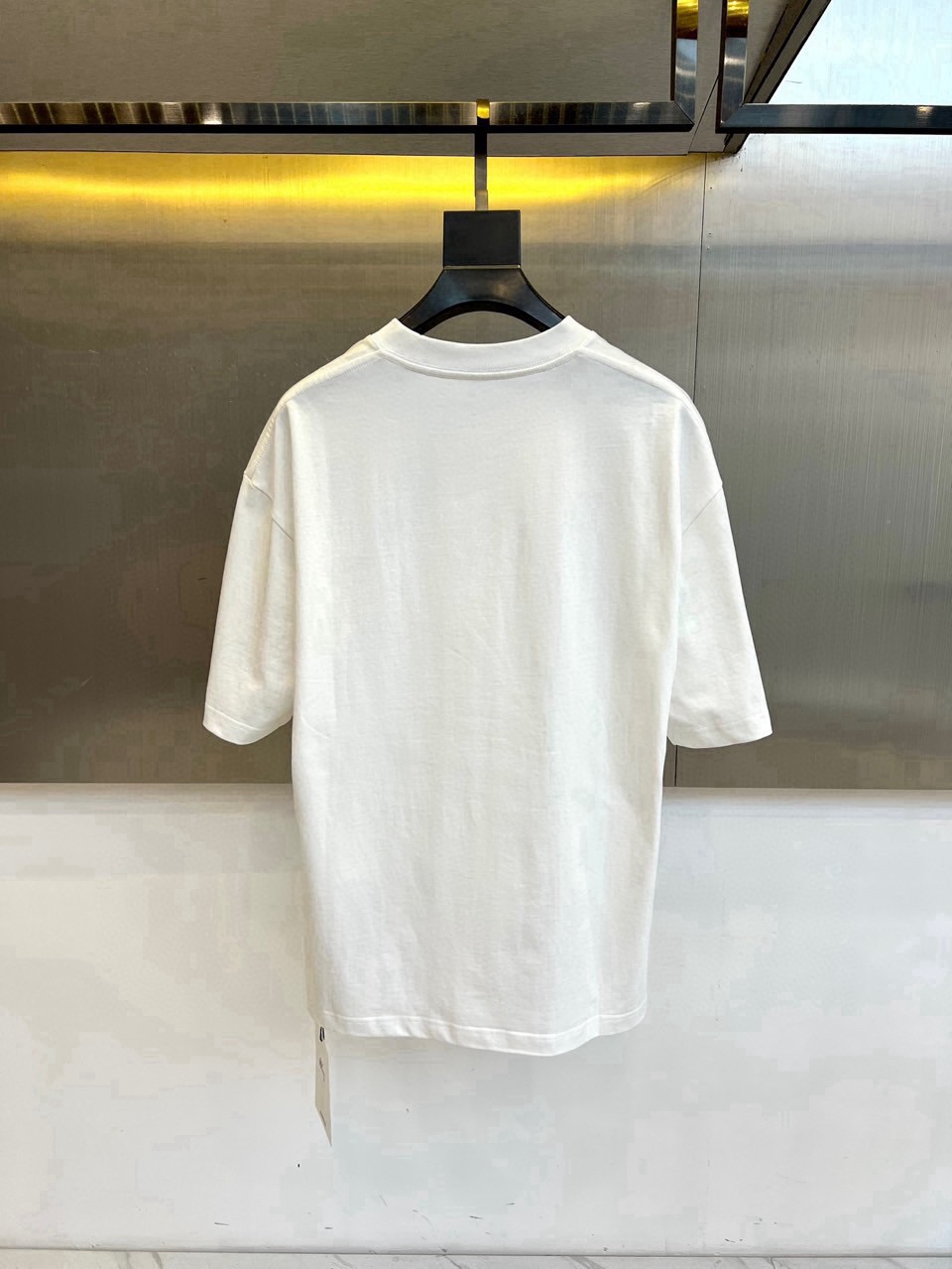 P75 DG 2026春夏新品经典短袖T恤，延续品牌标志性的简约美学与法式松弛感，以纯色为底色，左胸点缀小巧精致刺绣，精致不张扬，诠释低调高级的都市格调。宽松廓形剪裁，落肩设计搭配微阔下摆，包容各种身形，营造随性自在的穿着体验，无论是单穿还是叠搭皆能轻松驾驭。面料甄选高支棉质，触感柔软亲肤，透气性佳，适合春夏日常通勤、周末出游或轻社交场合。极简线条与自然垂坠感赋予衣身流动韵律，细节处彰显匠心工艺，下摆保留原厂吊牌，传递新品首发质感。这款T恤不仅是衣橱基础款，更是风格表达的点睛之笔——不喧哗，自有声。2026春夏，让爱与自由在衣襟间悄然绽放，穿出属于你的温柔力量与都市从容。S- XXL（模特173，140斤上身M码）