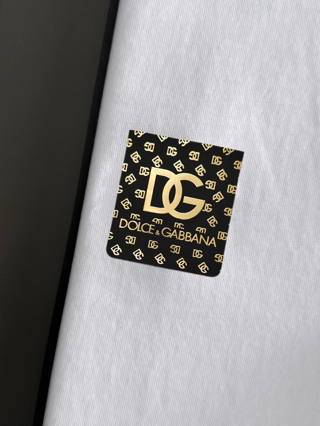 P75 DG专柜同款圆领短袖T恤 定制棉质面料 ！采用品牌Logo标志皮牌设计！ 立体感强！使整体高透气和柔软性的质感更加凸显，饱满的棉质感引起极度舒适。高端人士必备单品，原厂辅料三标齐全！男女同款！ 颜色：黑色 白色 尺码：S-xxL