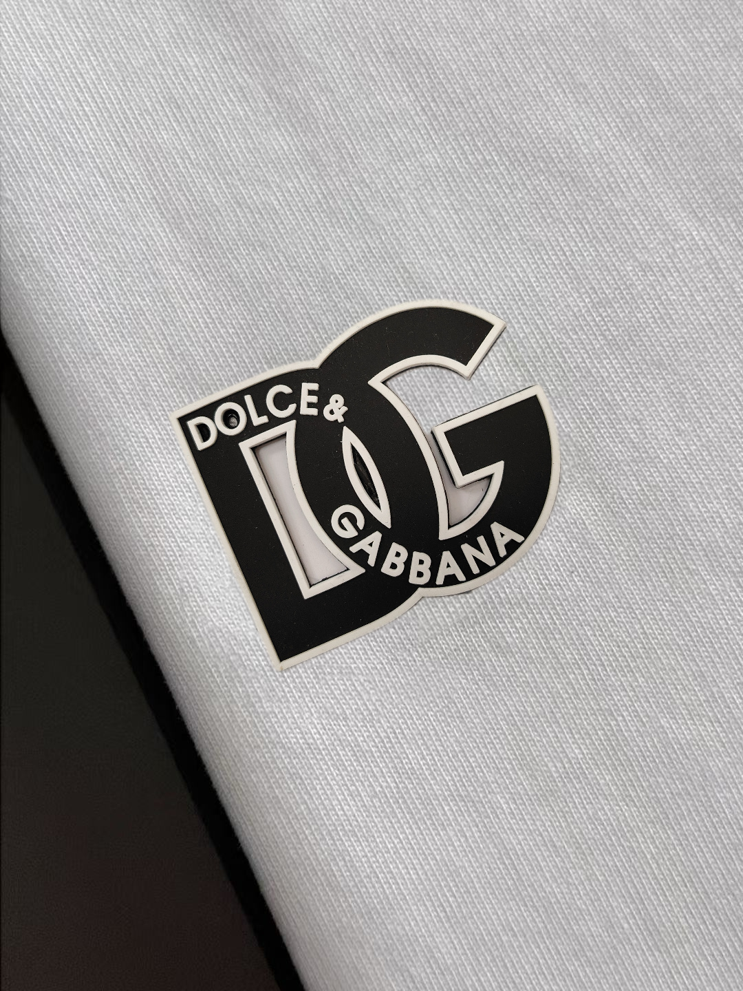 P75 DG专柜同款圆领短袖T恤 定制棉质面料 ！采用品牌DG Logo标志皮牌设计！ 立体感强！使整体高透气和柔软性的质感更加凸显，饱满的棉质感引起极度舒适。高端人士必备单品，原厂辅料三标齐全！男女同款！ 颜色：黑色 白色 尺码：S-xxL