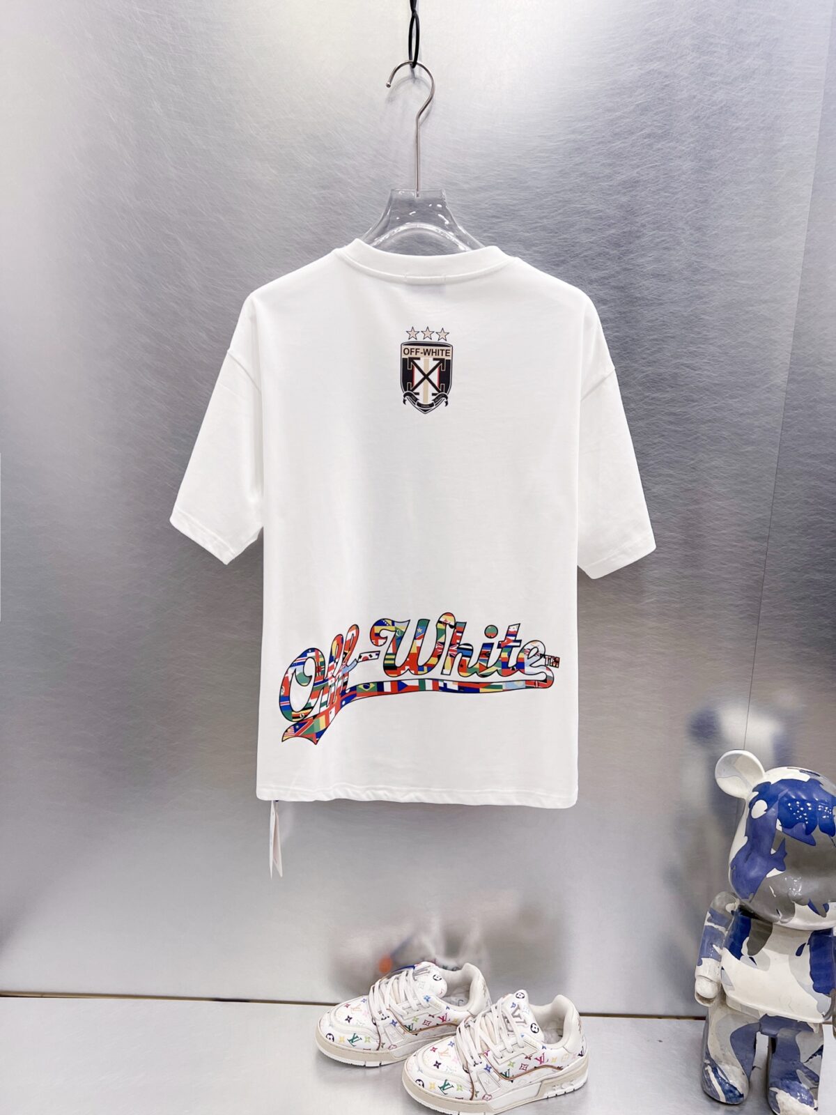 P75 OFF-WHITE 多国国旗足球印花短袖 世界杯徽章箭头重磅棉潮牌 T 恤，球迷潮人本命 OW 短袖来了！ 颜色：白色 尺码：S M L XL 整件衣服布满印满各国国旗的足球，每颗球都带有品牌标志性交叉箭头，侧边四星盾形徽章细节拉满，把世界杯环球氛围感直接穿身上。 重磅纯棉料子不透肉，宽松版型藏肉显瘦，看球约会日常穿都合适，喜欢足球和街头风的男生女生直接冲，情侣搭一套超吸睛！