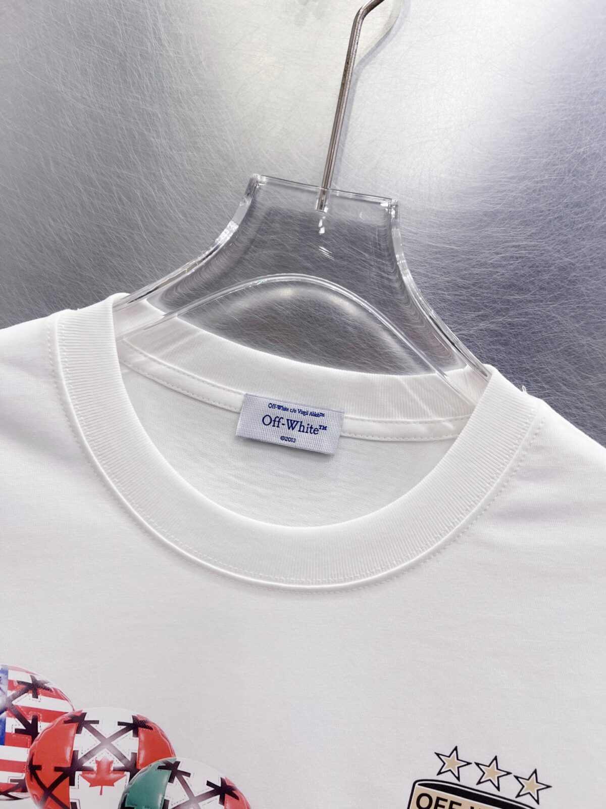 P75 OFF-WHITE 多国国旗足球印花短袖 世界杯徽章箭头重磅棉潮牌 T 恤，球迷潮人本命 OW 短袖来了！ 颜色：白色 尺码：S M L XL 整件衣服布满印满各国国旗的足球，每颗球都带有品牌标志性交叉箭头，侧边四星盾形徽章细节拉满，把世界杯环球氛围感直接穿身上。 重磅纯棉料子不透肉，宽松版型藏肉显瘦，看球约会日常穿都合适，喜欢足球和街头风的男生女生直接冲，情侣搭一套超吸睛！