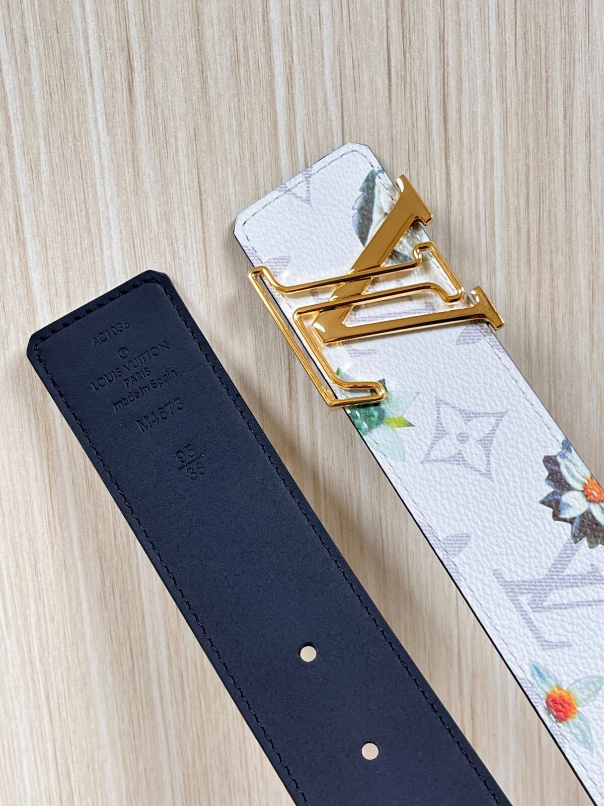 P150 当季新款，LV Initiales Monogram Flower系列40毫米可翻转腰带重新诠释了经典的LV标志，以唤起运动和情感的花纹。在画布一侧，Monogram通过添加白色和金色调的花朵，生动地描绘了每一片花瓣，赋予了它新的生命。白色的皮革背面同样优雅。 白花印百合花。