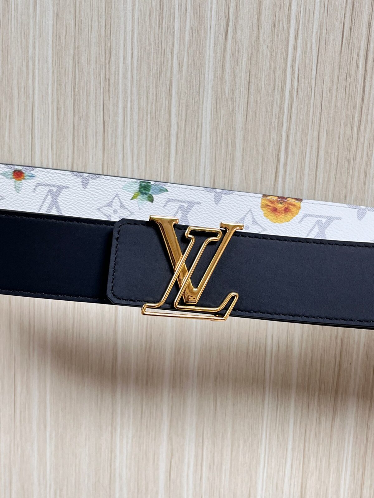 P150 当季新款，LV Initiales Monogram Flower系列40毫米可翻转腰带重新诠释了经典的LV标志，以唤起运动和情感的花纹。在画布一侧，Monogram通过添加白色和金色调的花朵，生动地描绘了每一片花瓣，赋予了它新的生命。白色的皮革背面同样优雅。 白花印百合花。