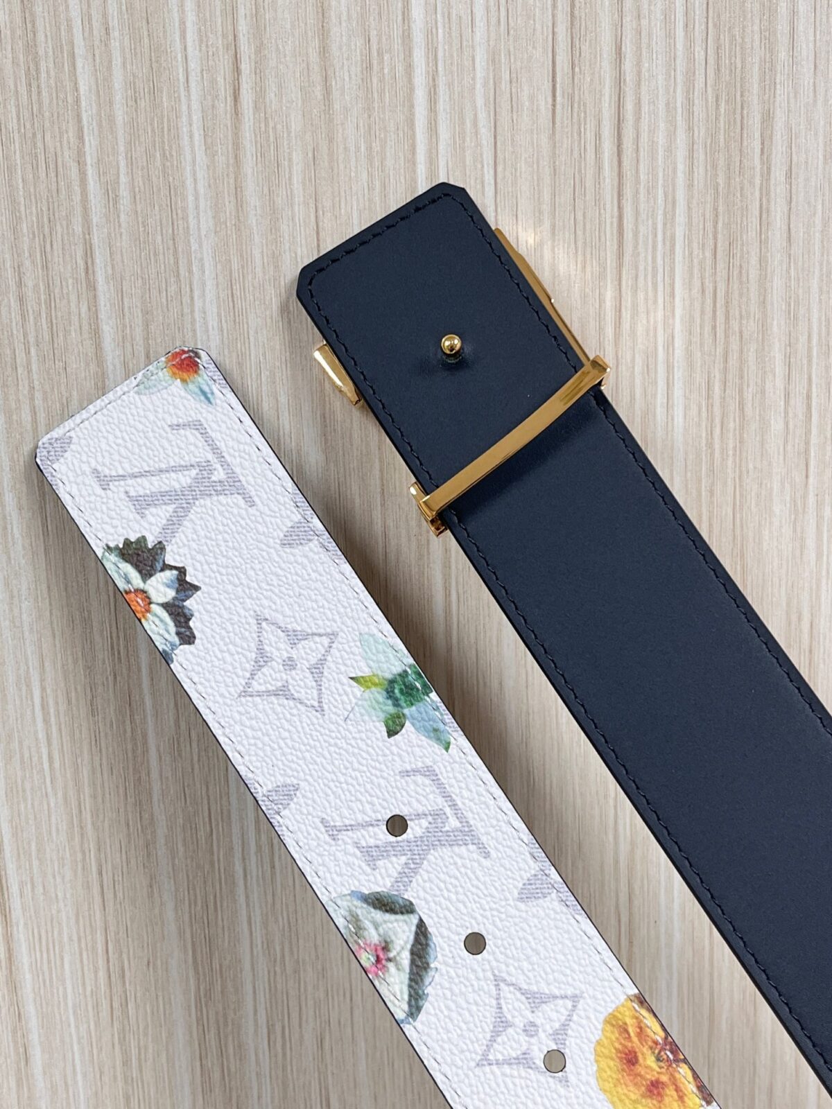 P150 当季新款，LV Initiales Monogram Flower系列40毫米可翻转腰带重新诠释了经典的LV标志，以唤起运动和情感的花纹。在画布一侧，Monogram通过添加白色和金色调的花朵，生动地描绘了每一片花瓣，赋予了它新的生命。白色的皮革背面同样优雅。 白花印百合花