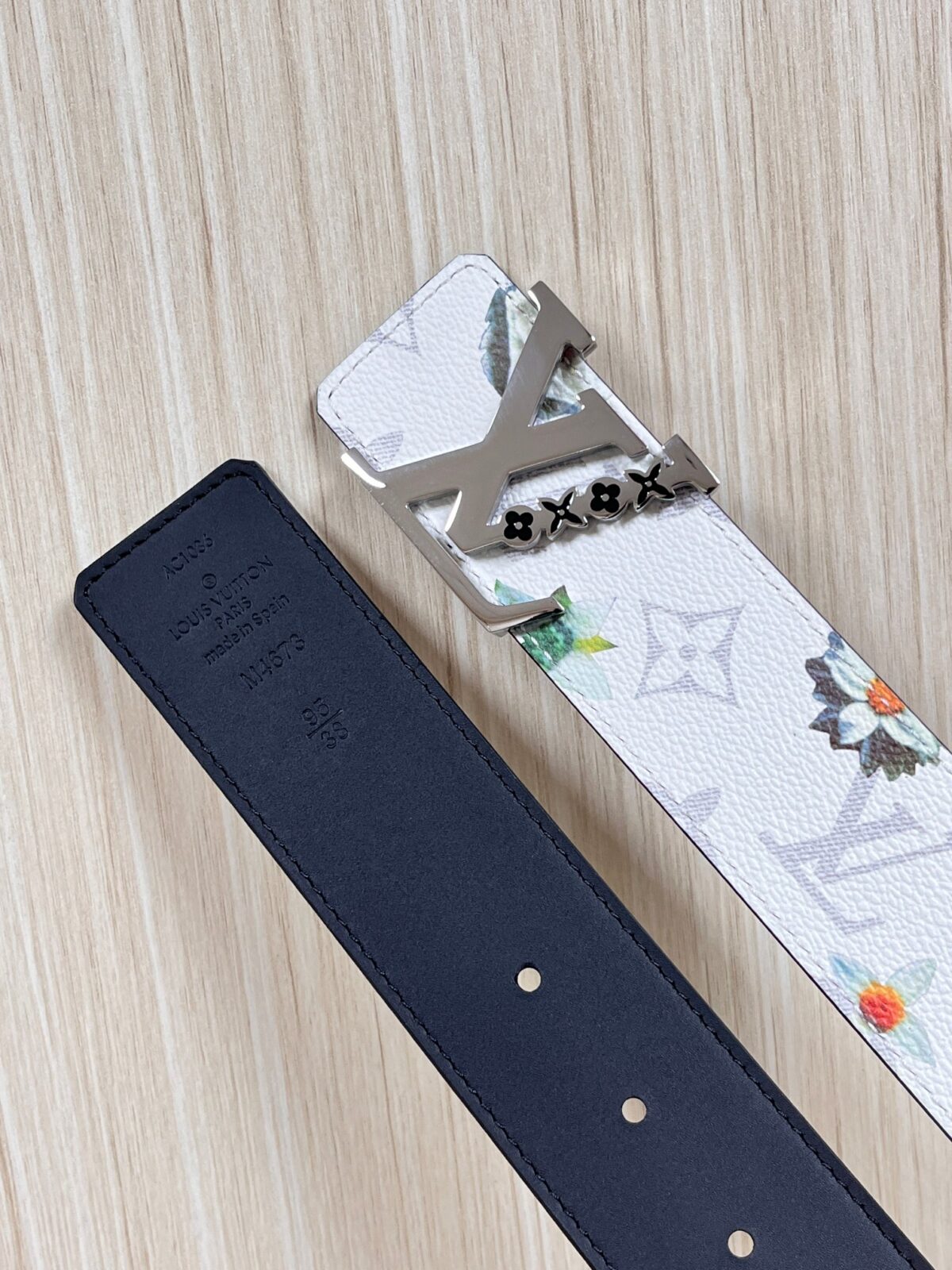 P150 当季新款，LV Initiales Monogram Flower系列40毫米可翻转腰带重新诠释了经典的LV标志，以唤起运动和情感的花纹。在画布一侧，Monogram通过添加白色和金色调的花朵，生动地描绘了每一片花瓣，赋予了它新的生命。白色的皮革背面同样优雅。 白花印百合花