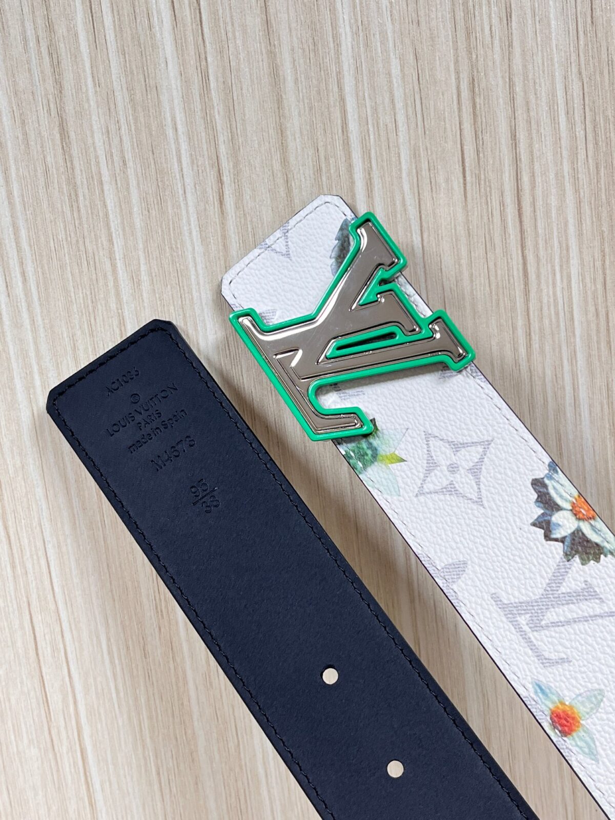 P150 当季新款，LV Initiales Monogram Flower系列40毫米可翻转腰带重新诠释了经典的LV标志，以唤起运动和情感的花纹。在画布一侧，Monogram通过添加白色和金色调的花朵，生动地描绘了每一片花瓣，赋予了它新的生命。白色的皮革背面同样优雅。 白花印百合花