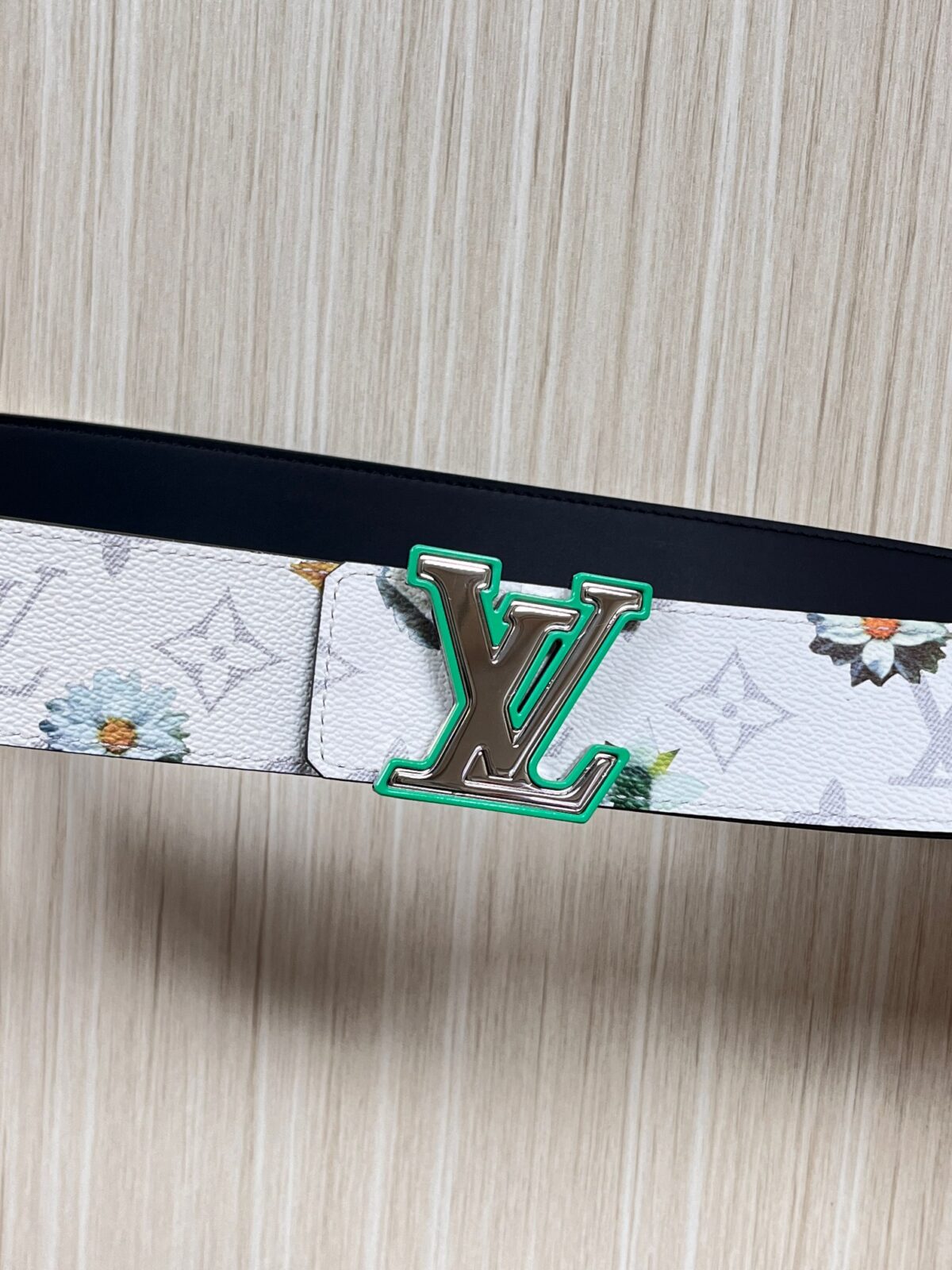 P150 当季新款，LV Initiales Monogram Flower系列40毫米可翻转腰带重新诠释了经典的LV标志，以唤起运动和情感的花纹。在画布一侧，Monogram通过添加白色和金色调的花朵，生动地描绘了每一片花瓣，赋予了它新的生命。白色的皮革背面同样优雅。 白花印百合花