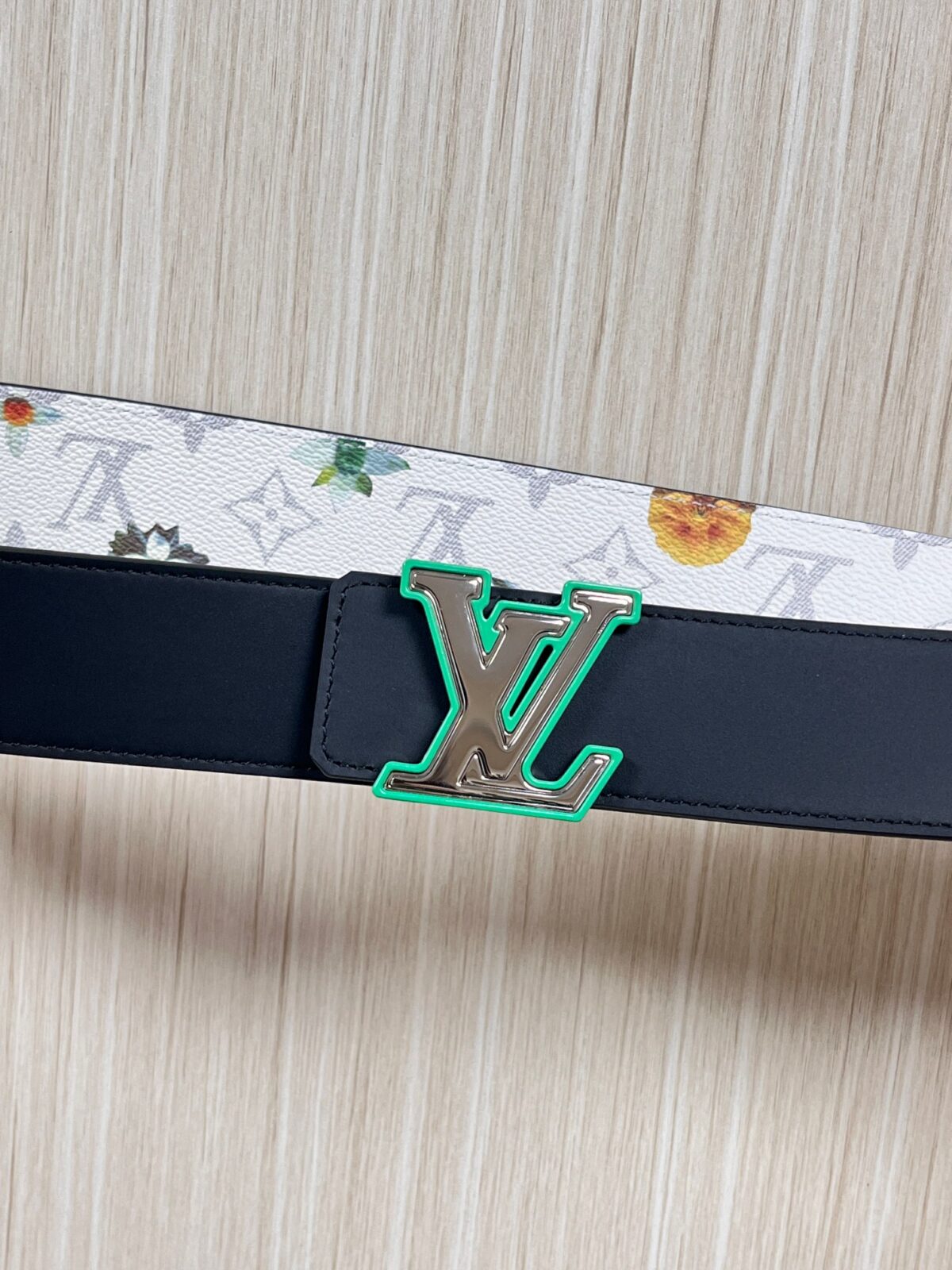 P150 当季新款，LV Initiales Monogram Flower系列40毫米可翻转腰带重新诠释了经典的LV标志，以唤起运动和情感的花纹。在画布一侧，Monogram通过添加白色和金色调的花朵，生动地描绘了每一片花瓣，赋予了它新的生命。白色的皮革背面同样优雅。 白花印百合花